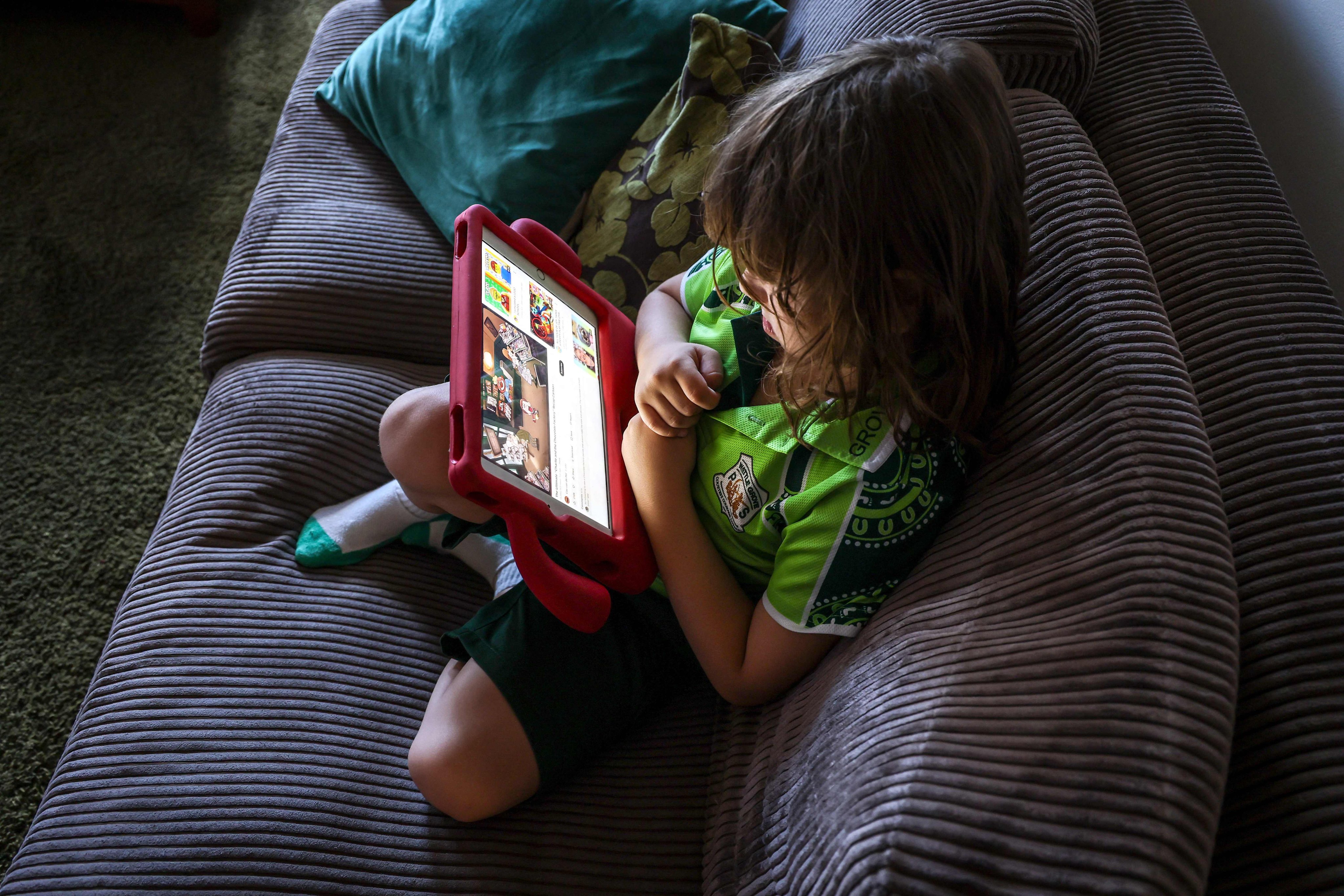 Six-year-old Enrique Navarro watches a show on YouTube at his home in western Sydney on October 30. Photo: AFP