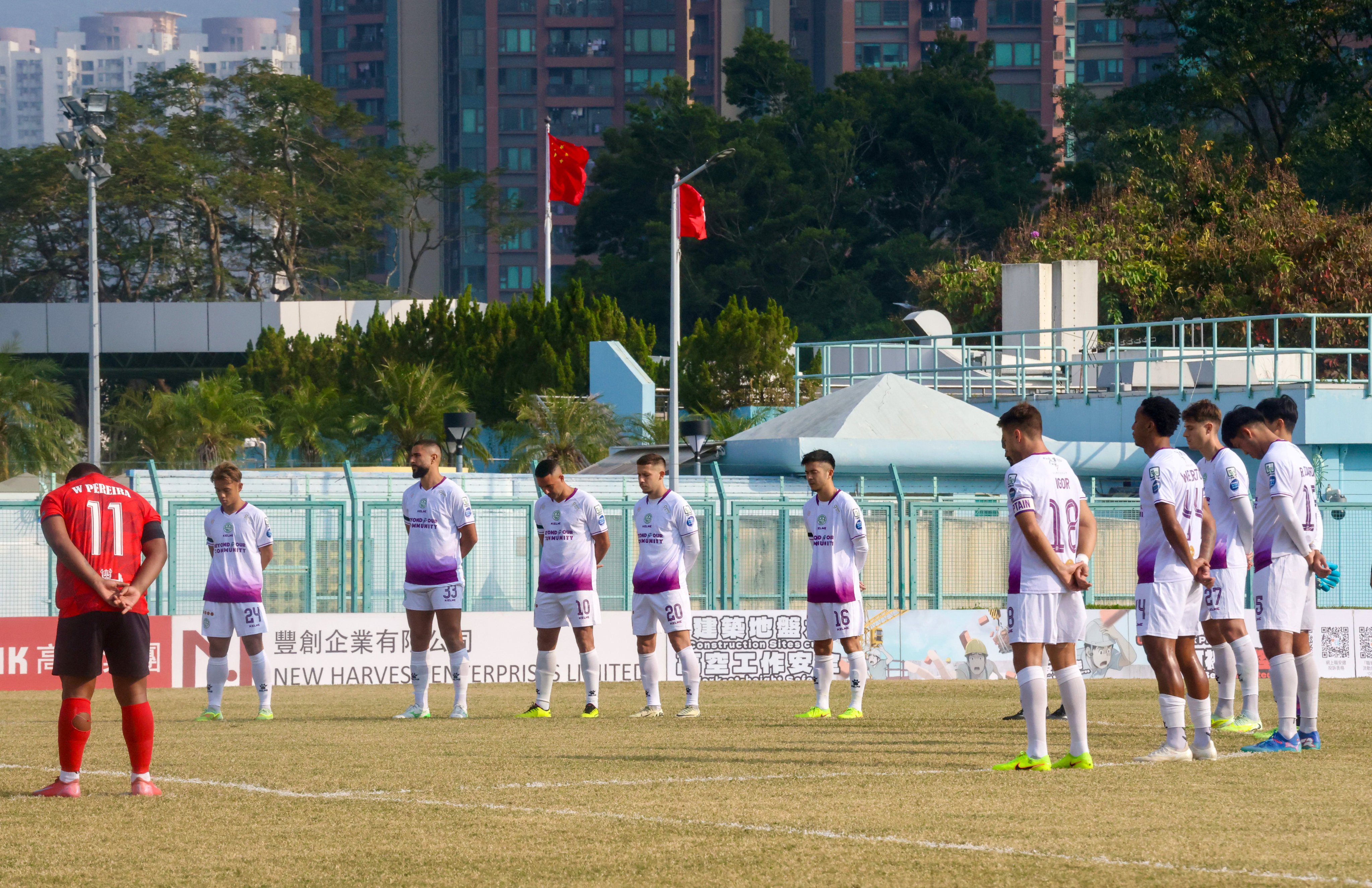 Players observe a minute’s silence before the Premier League match between Tai Po (in white) and North District. Photo: Jonathan Wong