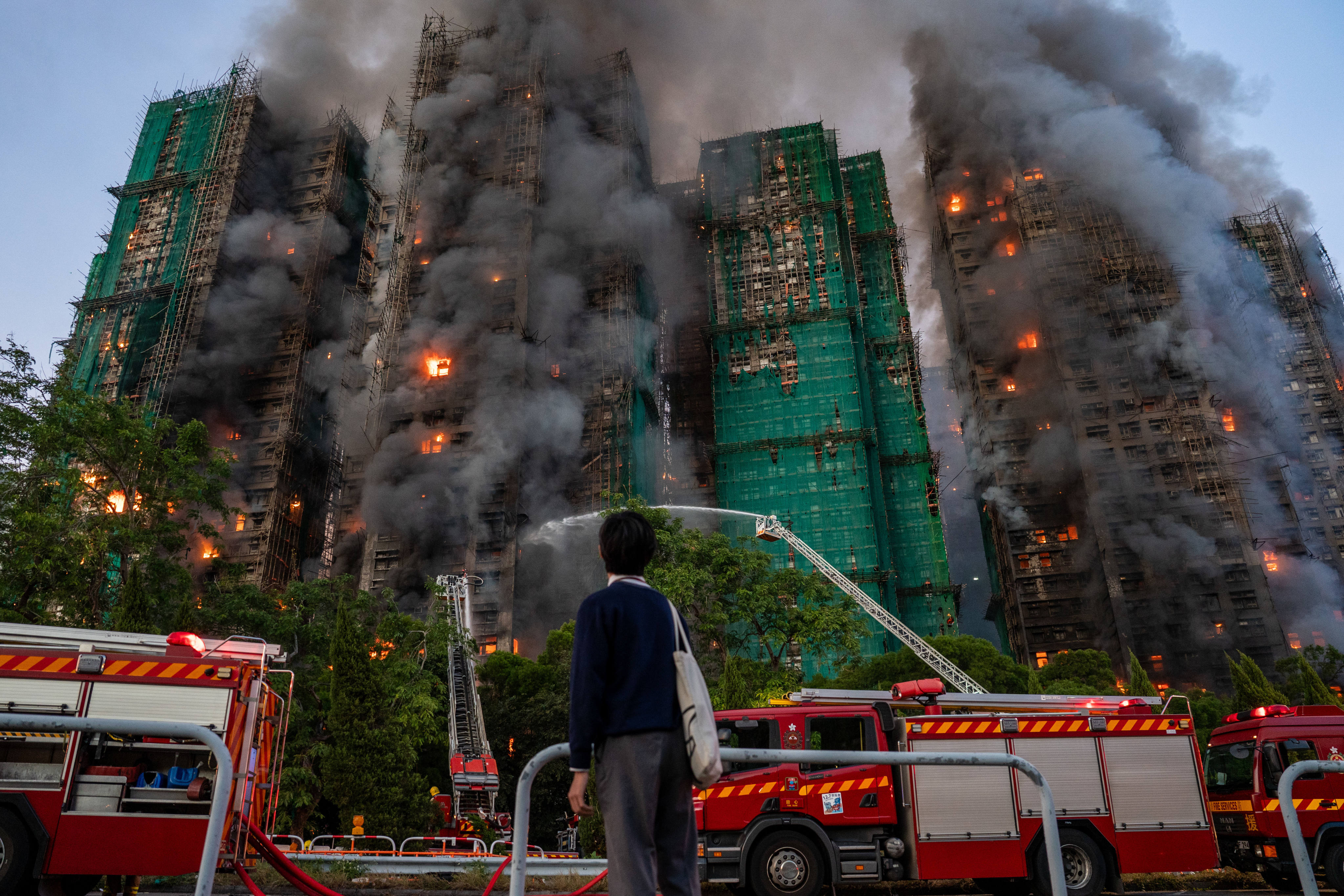 A person watches as a major fire engulfs residential buildings at Wang Fuk Court in Hong Kong on November 26. Photo: dpa
