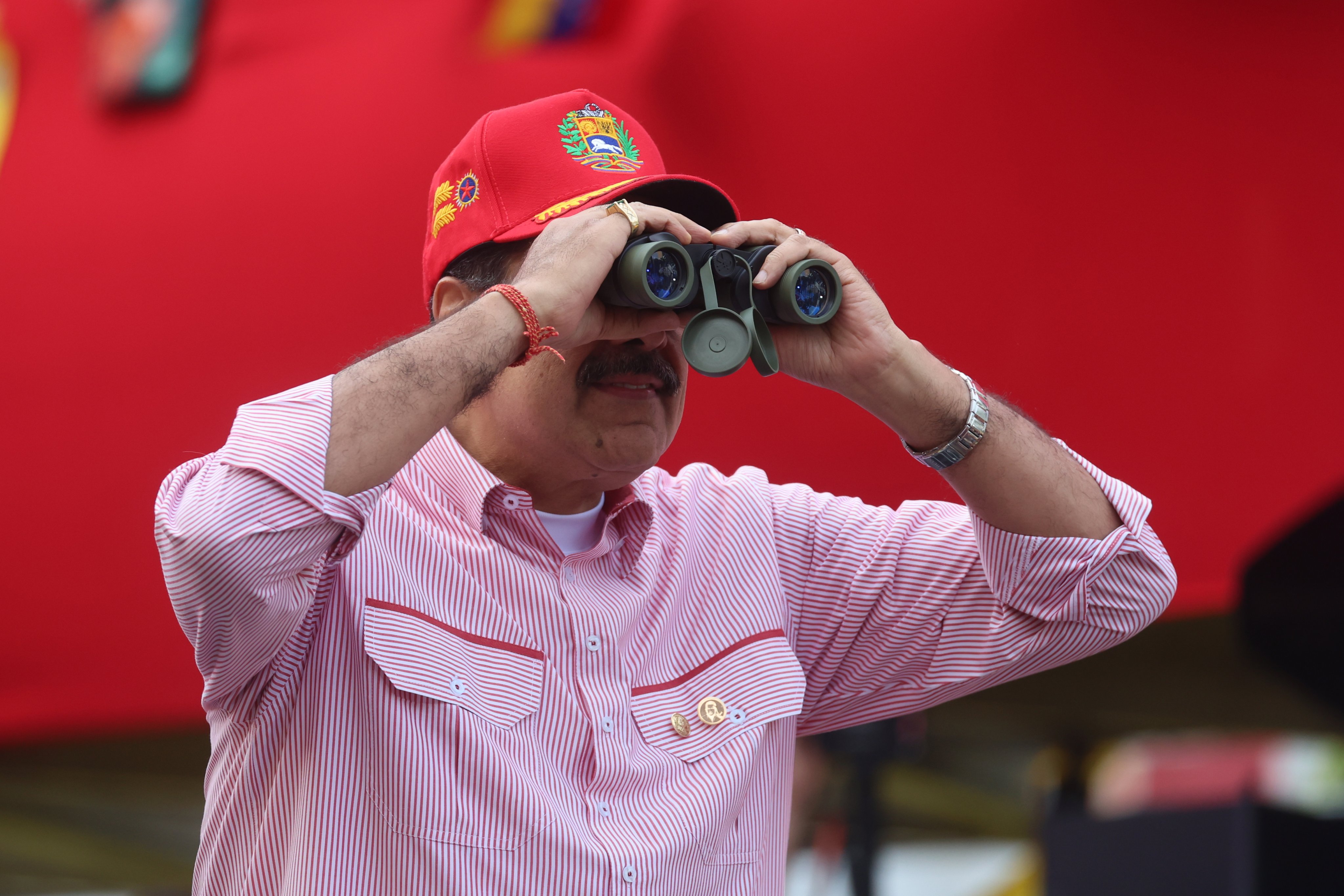 Venezuelan President Nicolas Maduro looks through binoculars during a rally in Caracas on Monday. Photo EPA
