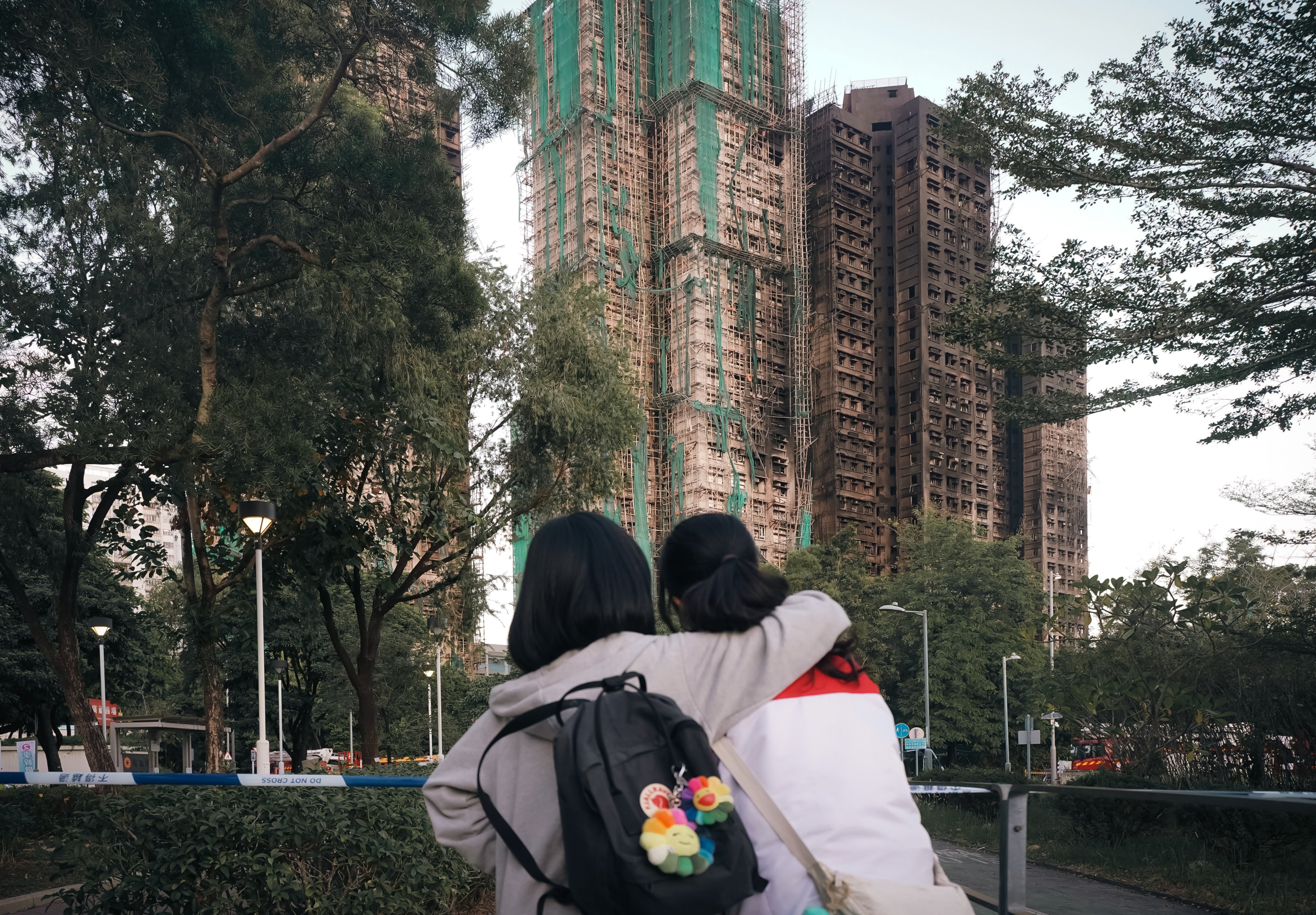 Friends Irena Leung (left) and Valerie Kwok, both 15, hug in front of the Wang Fuk Court housing estate, in Tai Po, on November 28. Photo: Alexander Mak