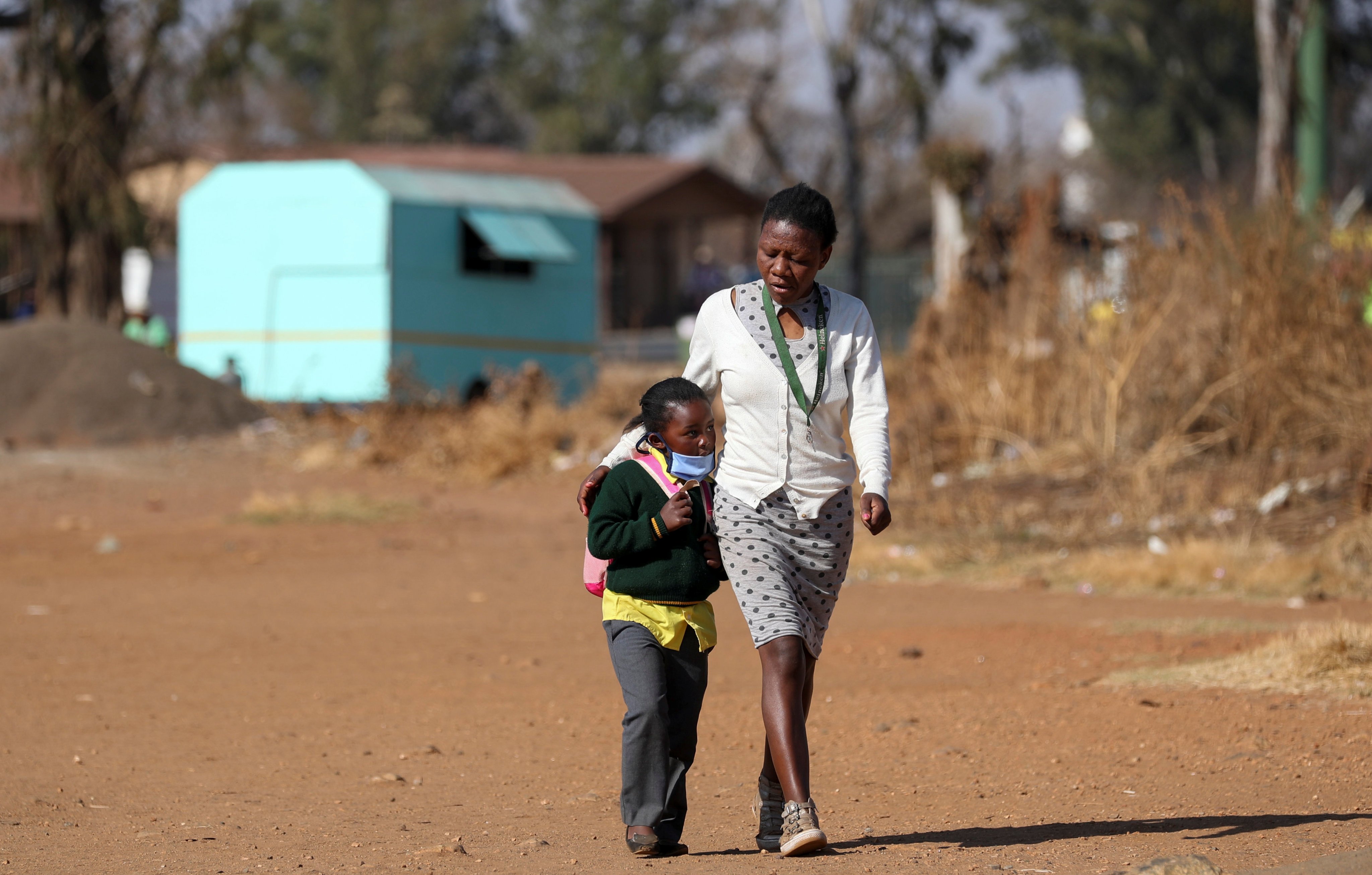 A woman walks her daughter to school in Eikenhof, South Africa, on August 24, 2020. Photo: Reuters
