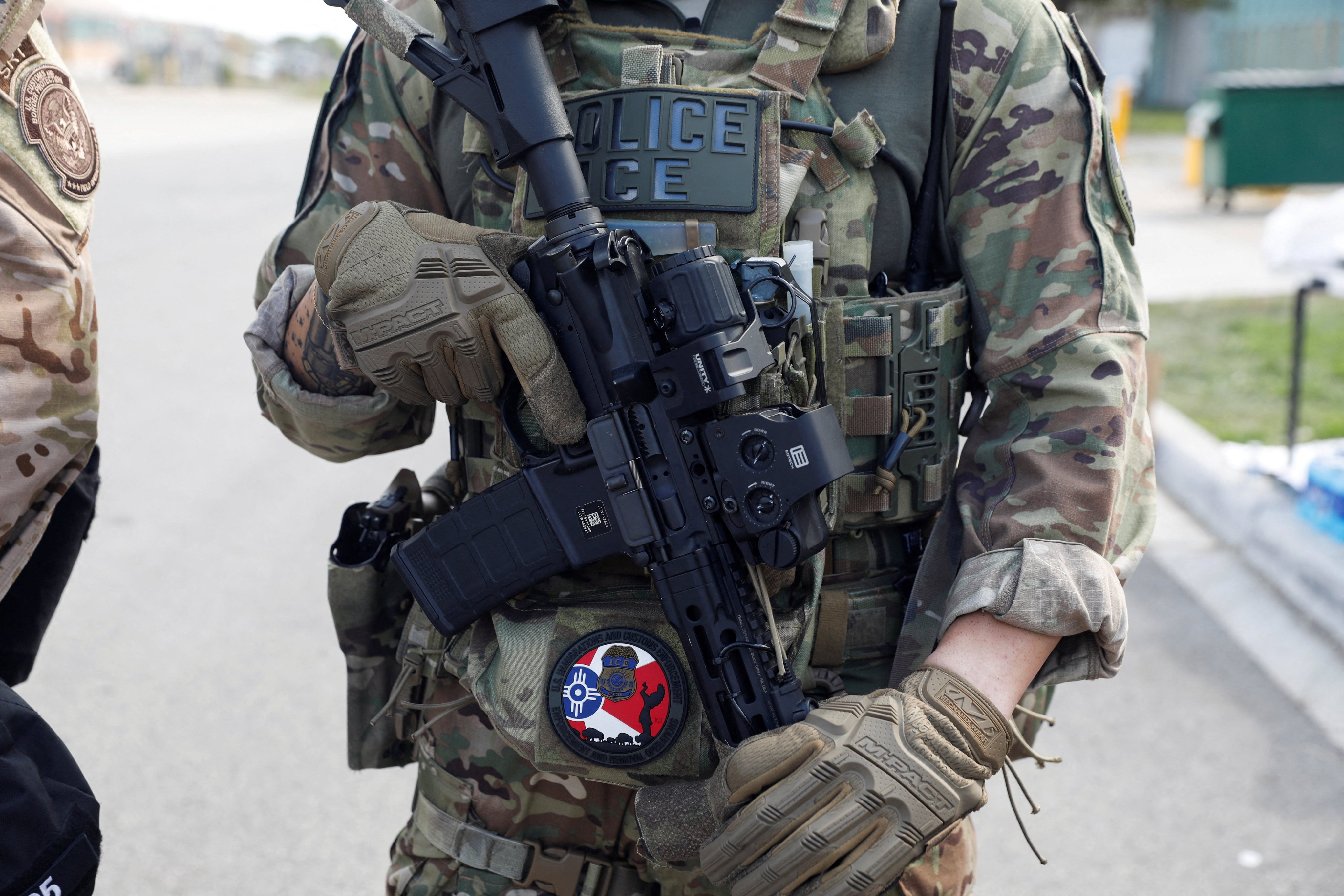 A US Immigration and Customs Enforcement (ICE) officer holds a weapon during a protest outside an ICE facility on September 12. Photo: Reuters