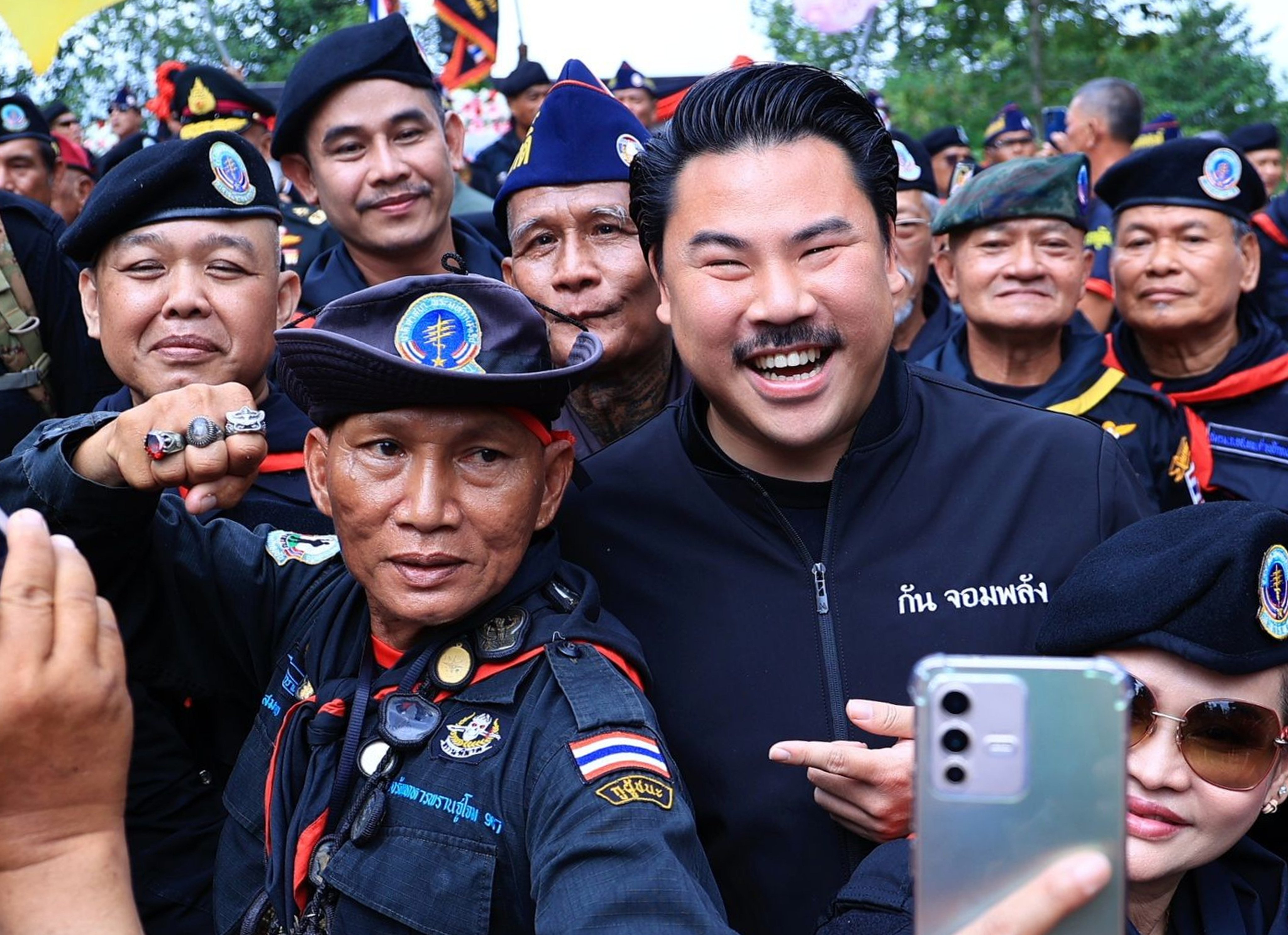 Self-styled social media influencer Gun Jompalang with Thai officers. Photo: Handout