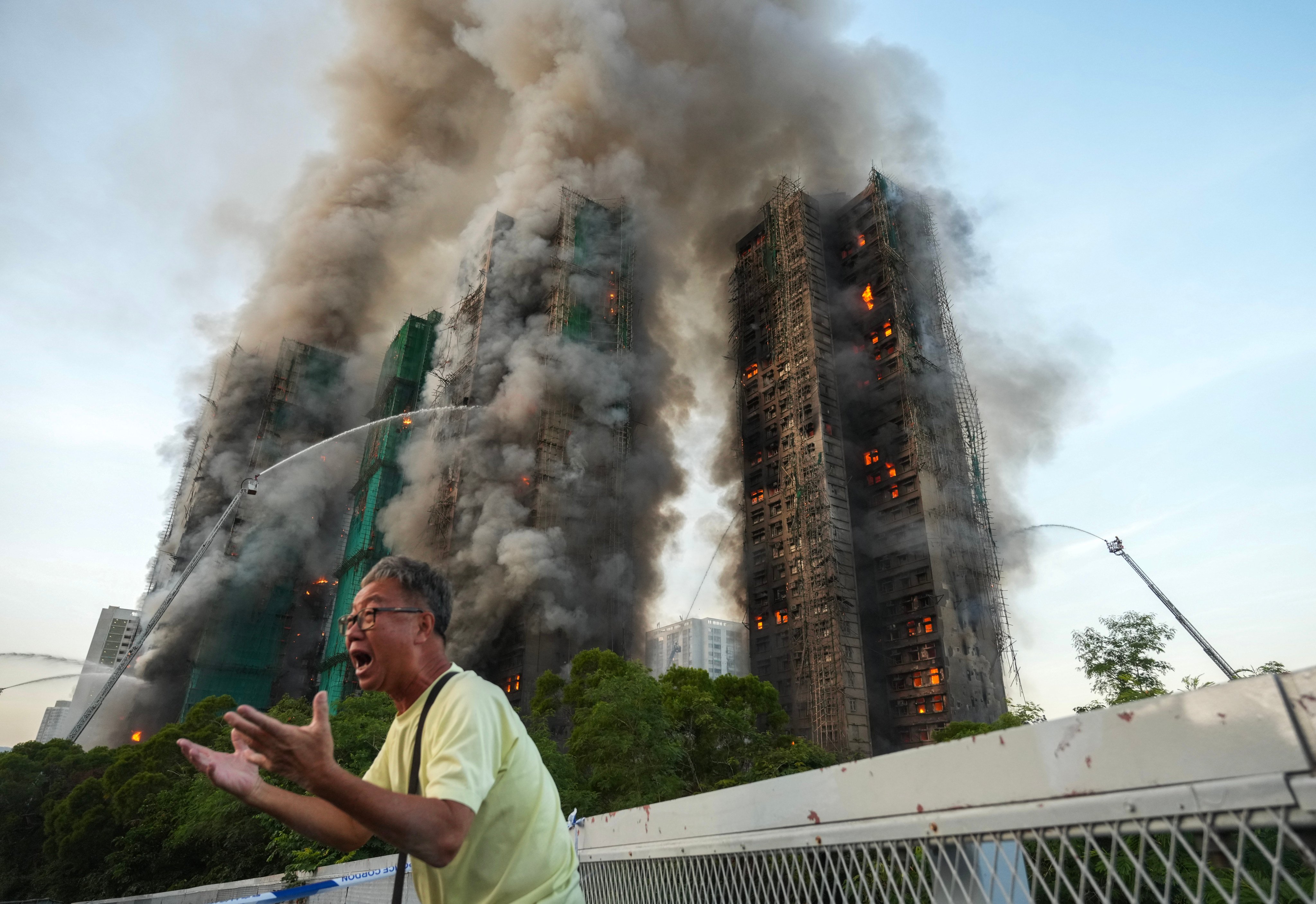A 71-year-old man, surnamed Wong, breaks down in tears, saying his wife is trapped inside Wang Fuk Court as the fire engulfs the housing blocks in Tai Po on November 26. Photo: Sam Tsang