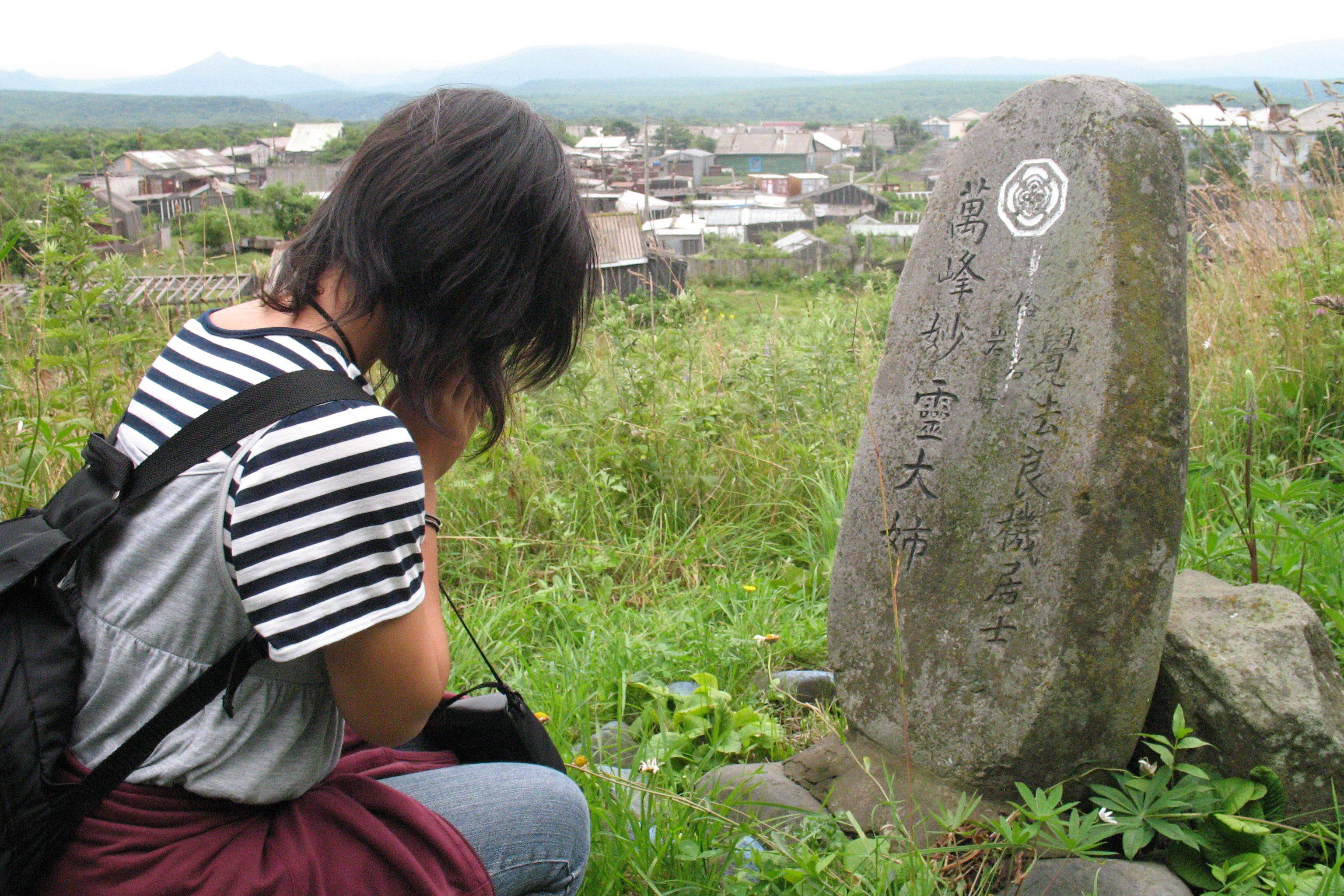 A Japanese student prays at a grave of a former islands on Iturup, also known as Etorofu, in 2007. Photo: AFP