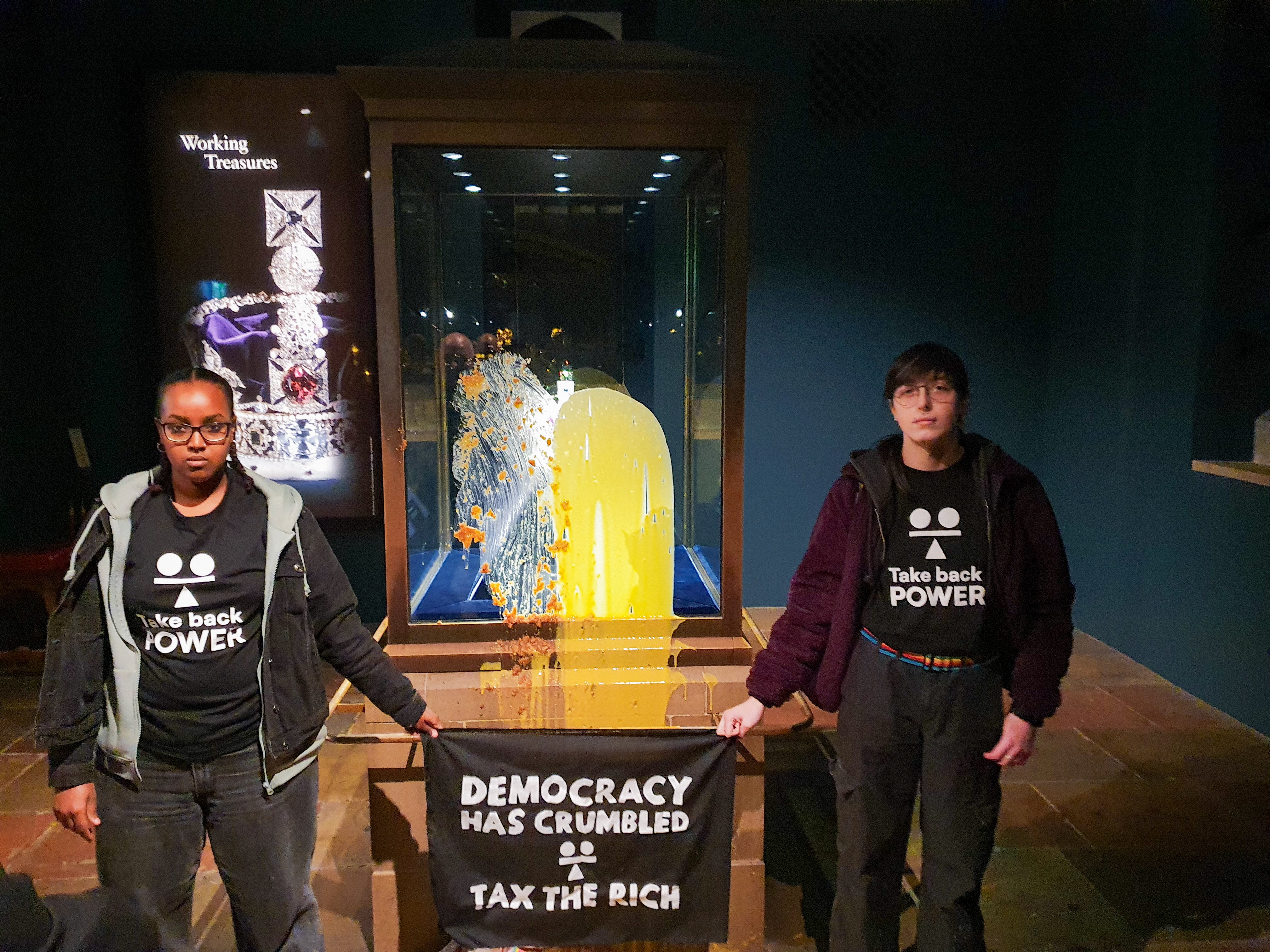 Two supporters of Take Back Power group after dessert was thrown over the Crown Jewels in the Tower of London. Four protesters were arrested for throwing food at the display case. Photo: Take Back Power/PA Media/dpa