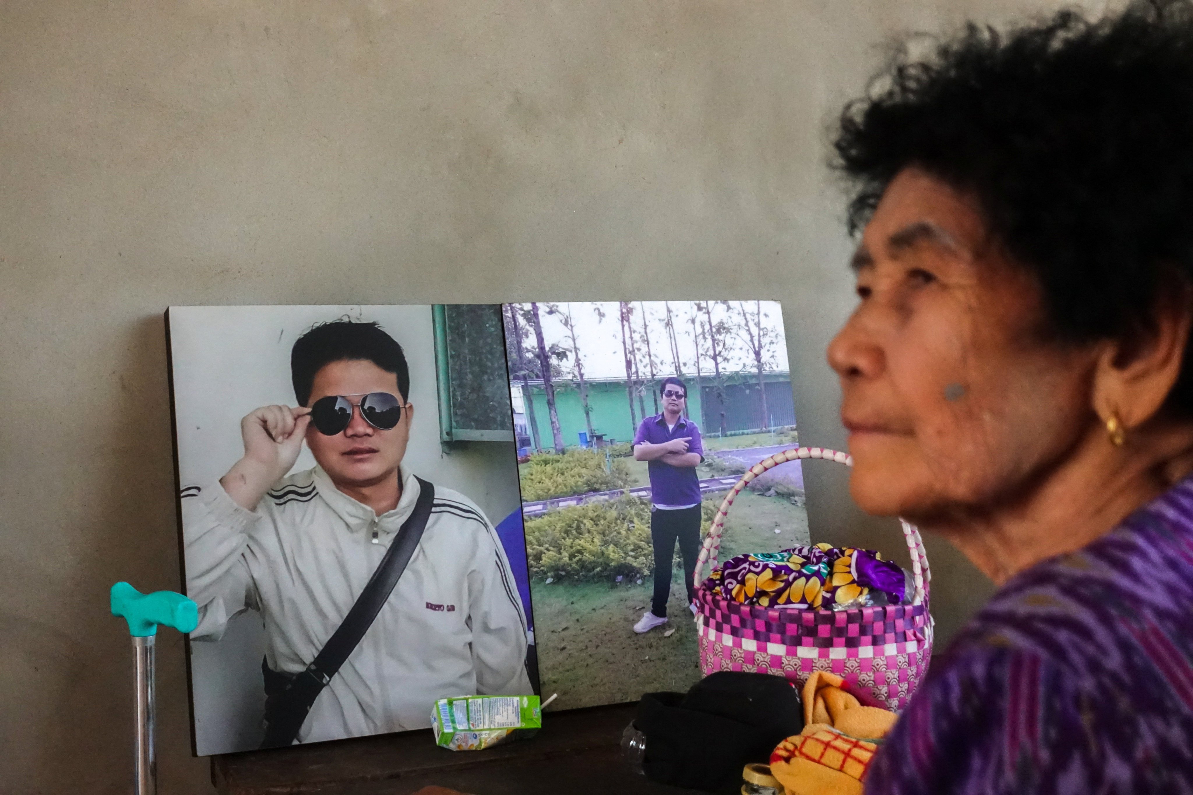 On Rinthalak, 80, mother of deceased Thai hostage Sudthisak Rinthalak, sits next to his pictures at their house in Nong Khai province, Thailand, on Friday. Photo: Reuters