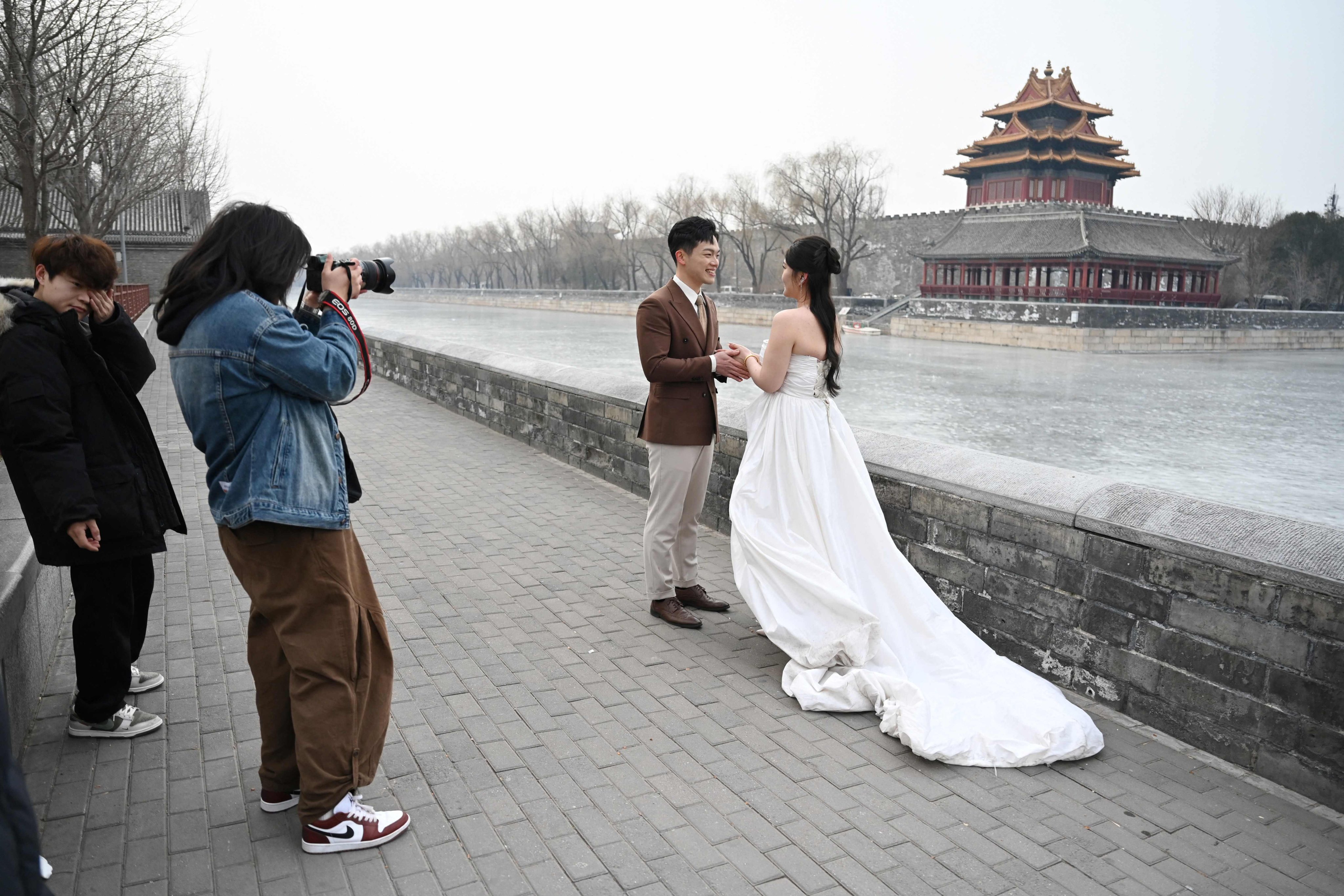 A couple poses for wedding photos outside the Forbidden City in Beijing, China on February 11. Photo: AFP
