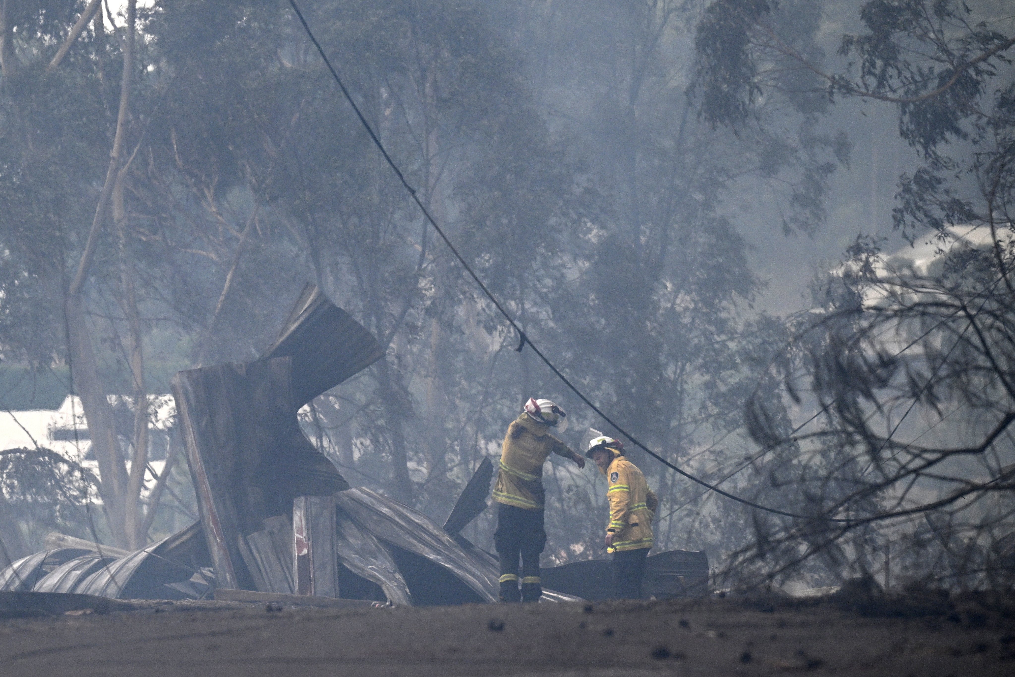 Firefighters work to put out a bushfire spreading through the Koolewong area on the Central Coast, New South Wales, on Saturday. Photo: EPA