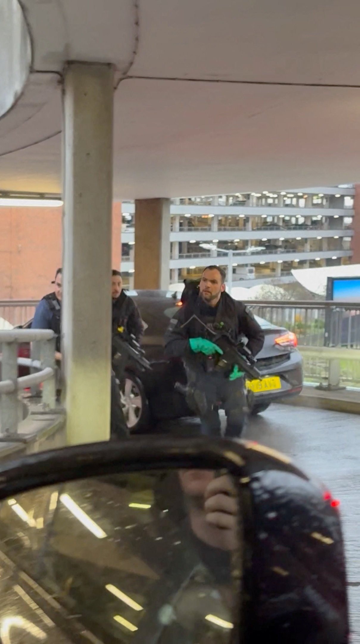 Armed officers respond at Heathrow Airport on Sunday, as seen through a car windscreen. Photo: Tom Bate via Reuters