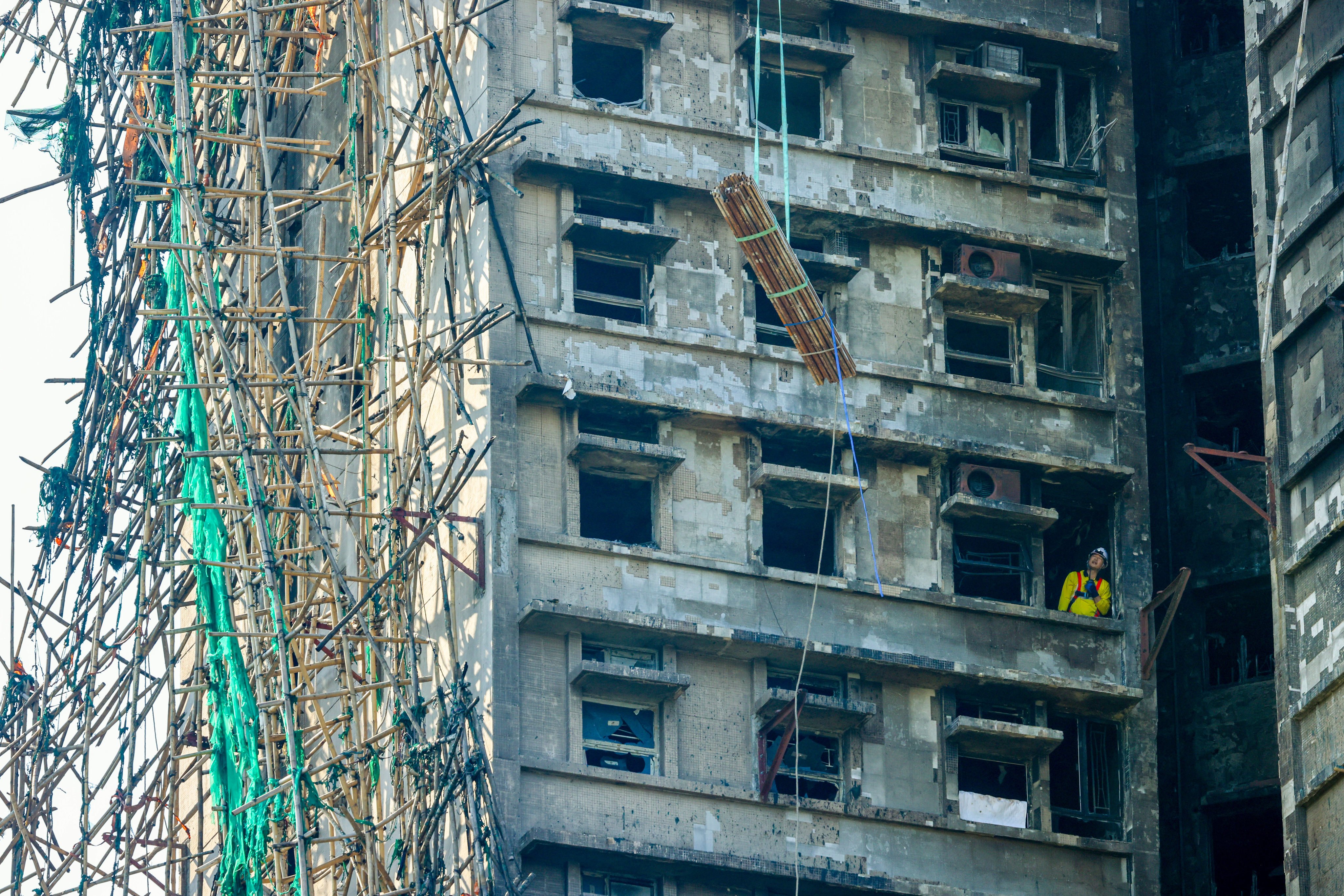 Bundles of steel bars being lifted to the upper floors of Wang Cheong House, the first building in Wang Fuk Court that caught fire on November 26. Photo: Dickson Lee