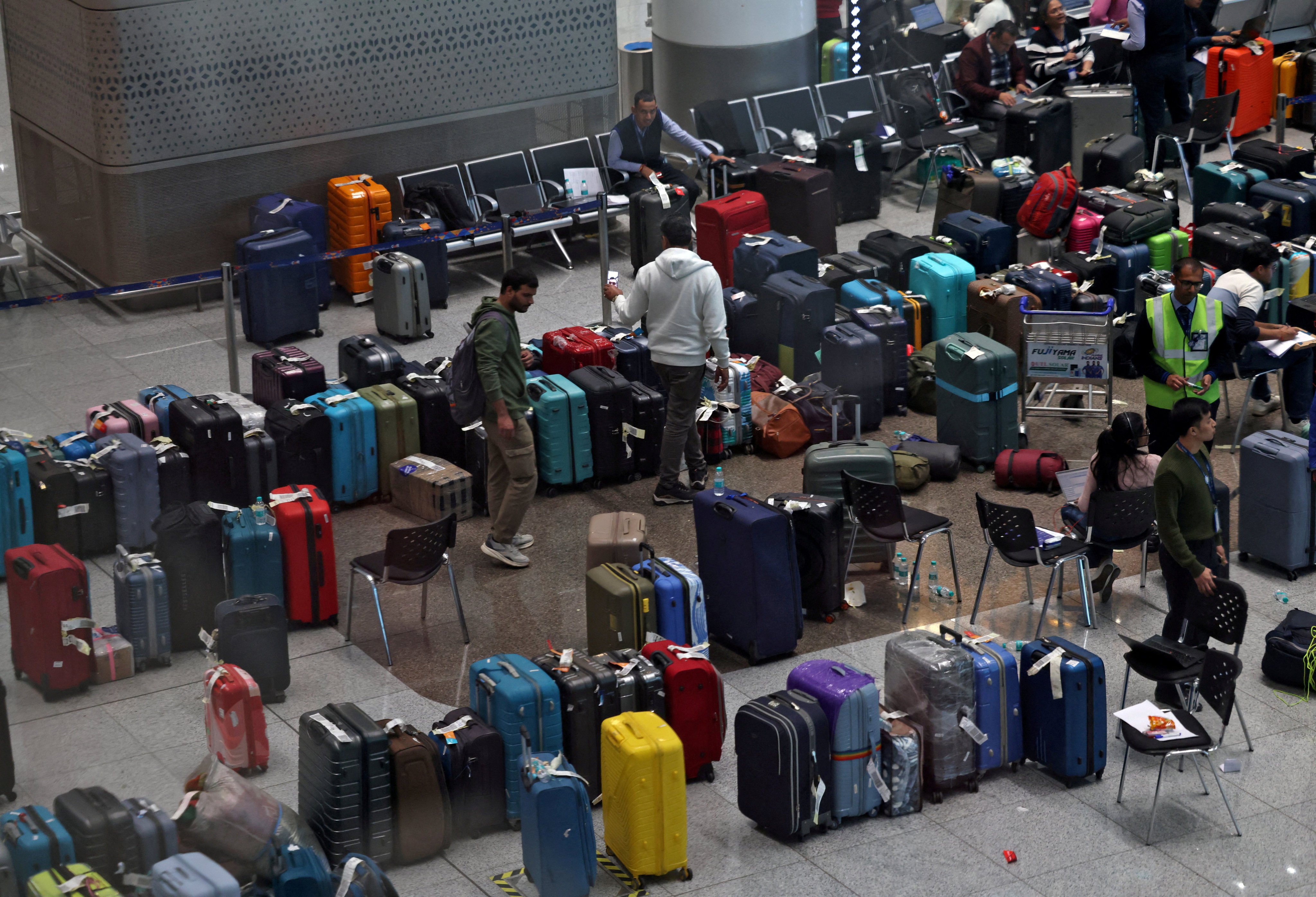 IndiGo employees tag stranded bags belonging to the airline’s passengers at Indira Gandhi International Airport in New Delhi on Monday following large-scale flight disruptions. Photo: Reuters