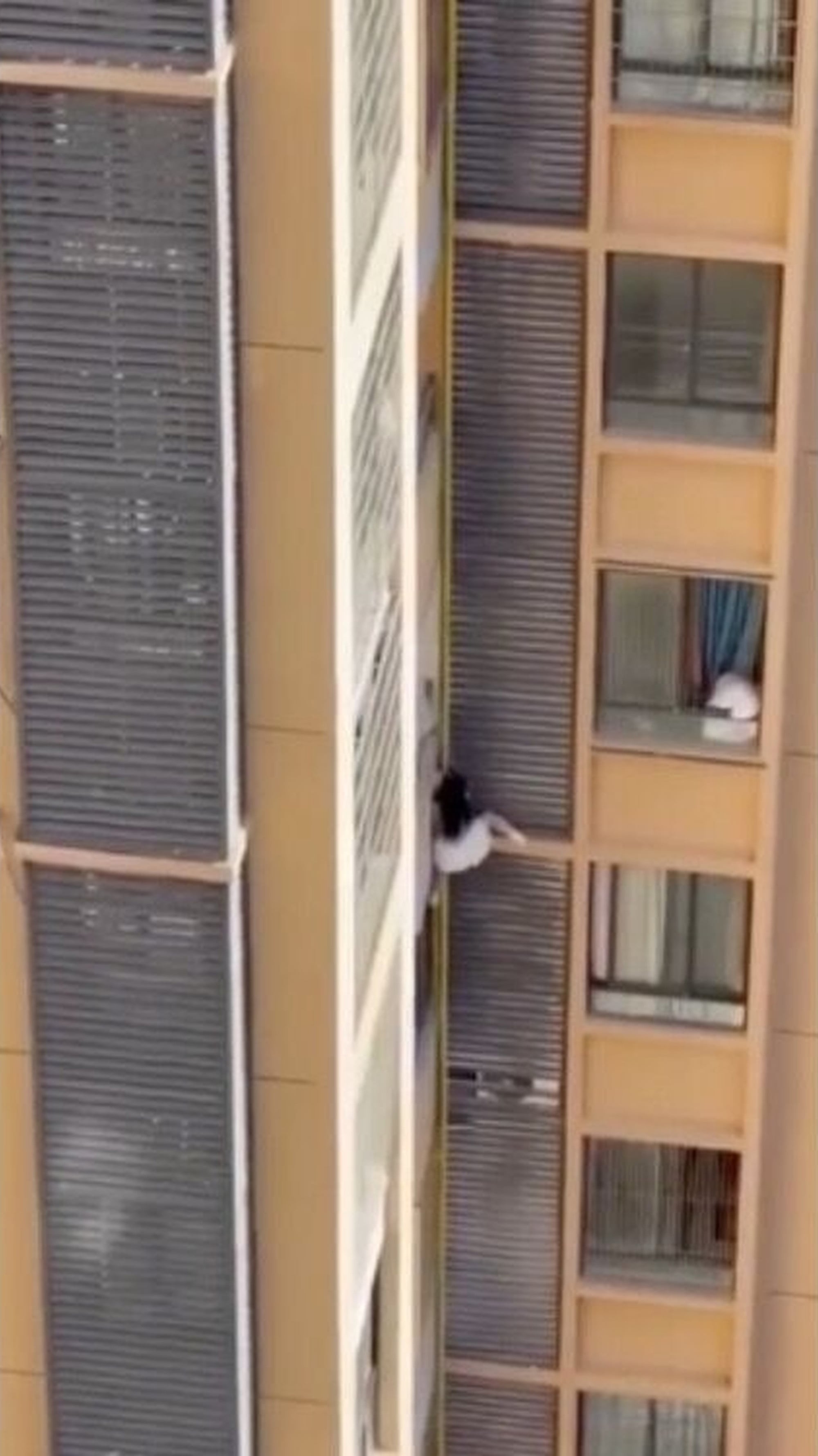 The daring woman shows the agility of a mountain goat as she clings onto the high-rise. Photo: ettoday.net