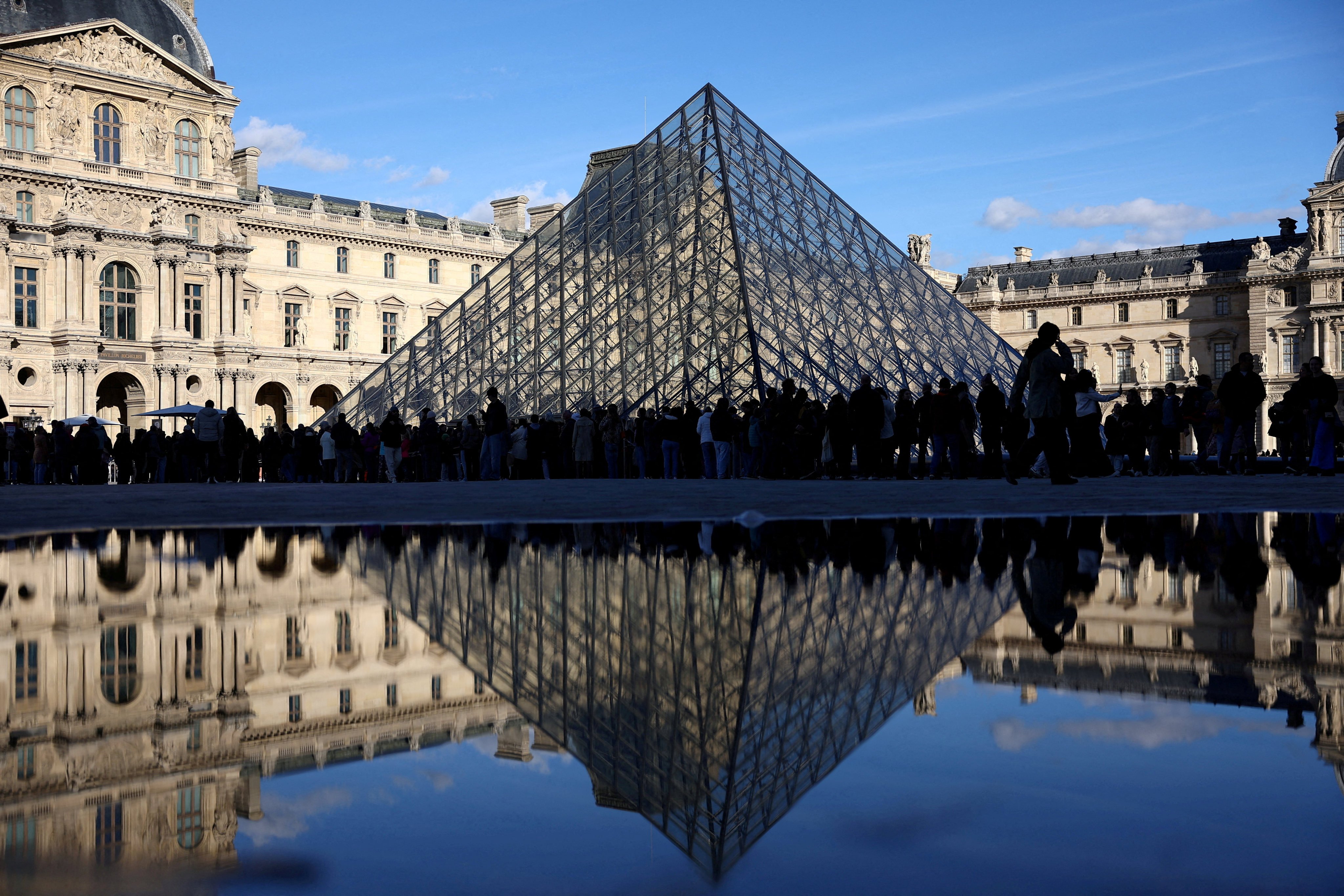 Visitors stand outside the Louvre Museum in Paris, France. Photo: Reuters