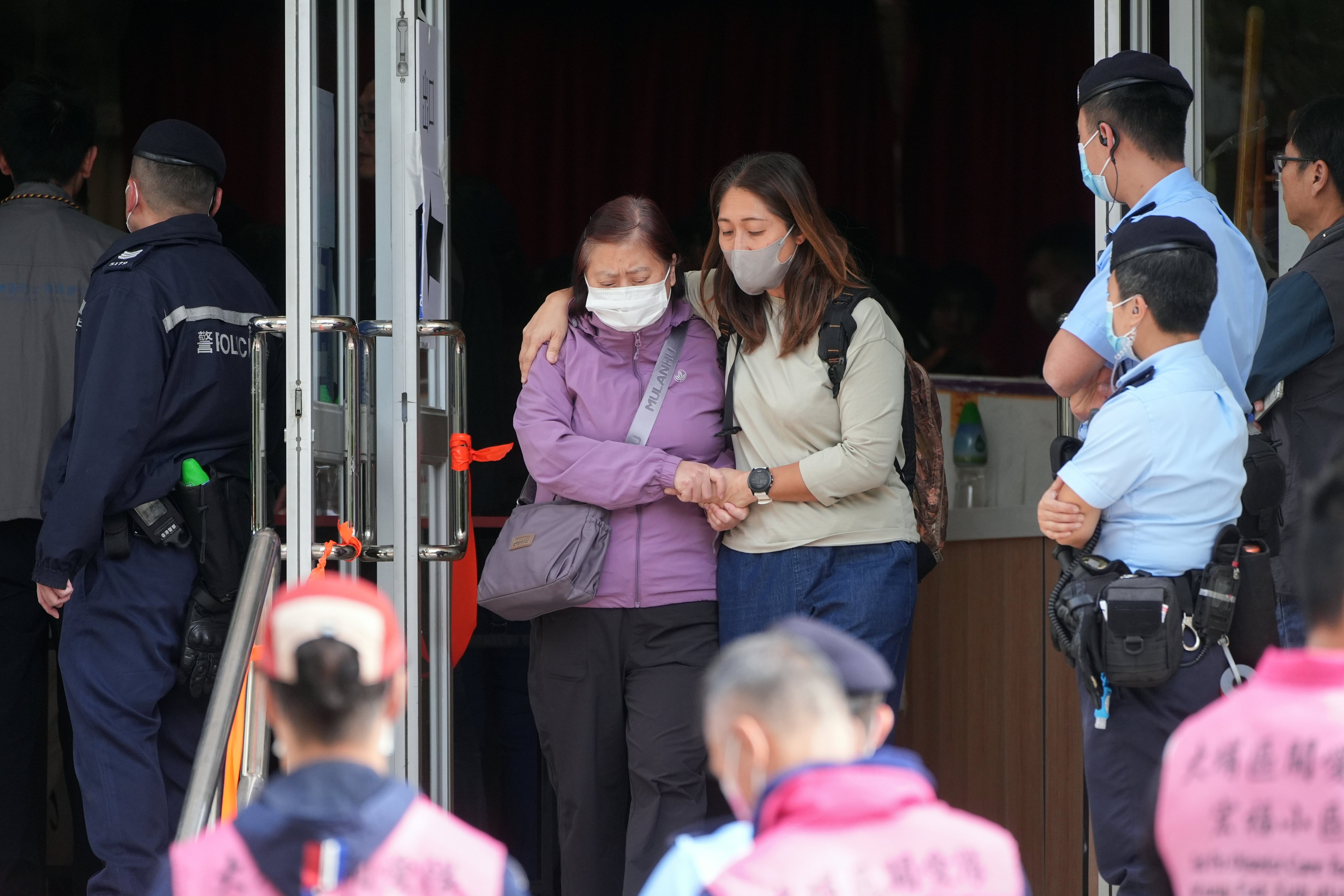People embrace each other after identifying deceased relatives at Kwong Fuk Community Hall on November 27, after the deadly Wang Fuk Court fire in Tai Po. Photo: Eugene Lee