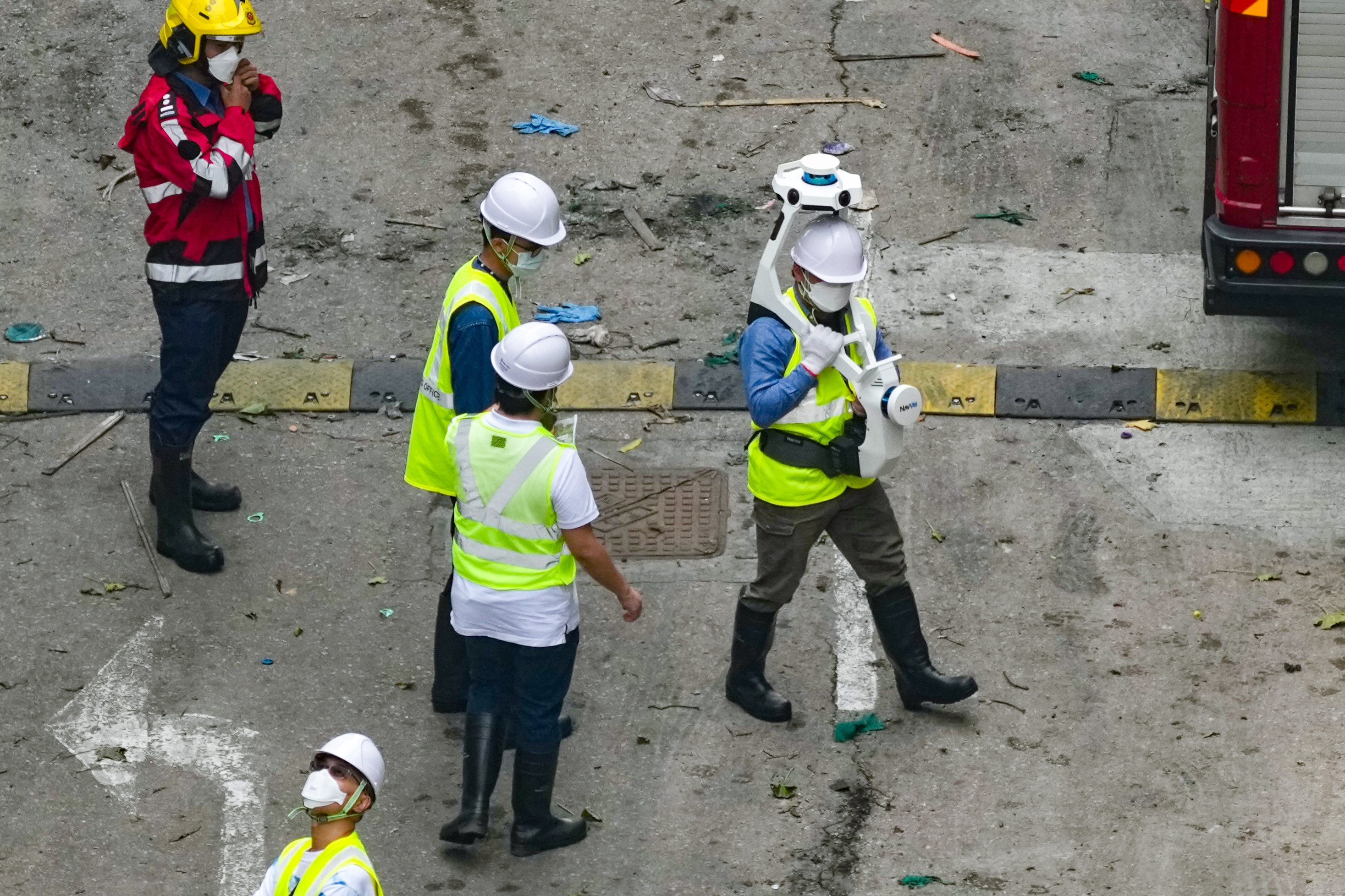 Officials carry out a survey at the scene of the deadly Tai Po blaze. Photo: Karma Lo