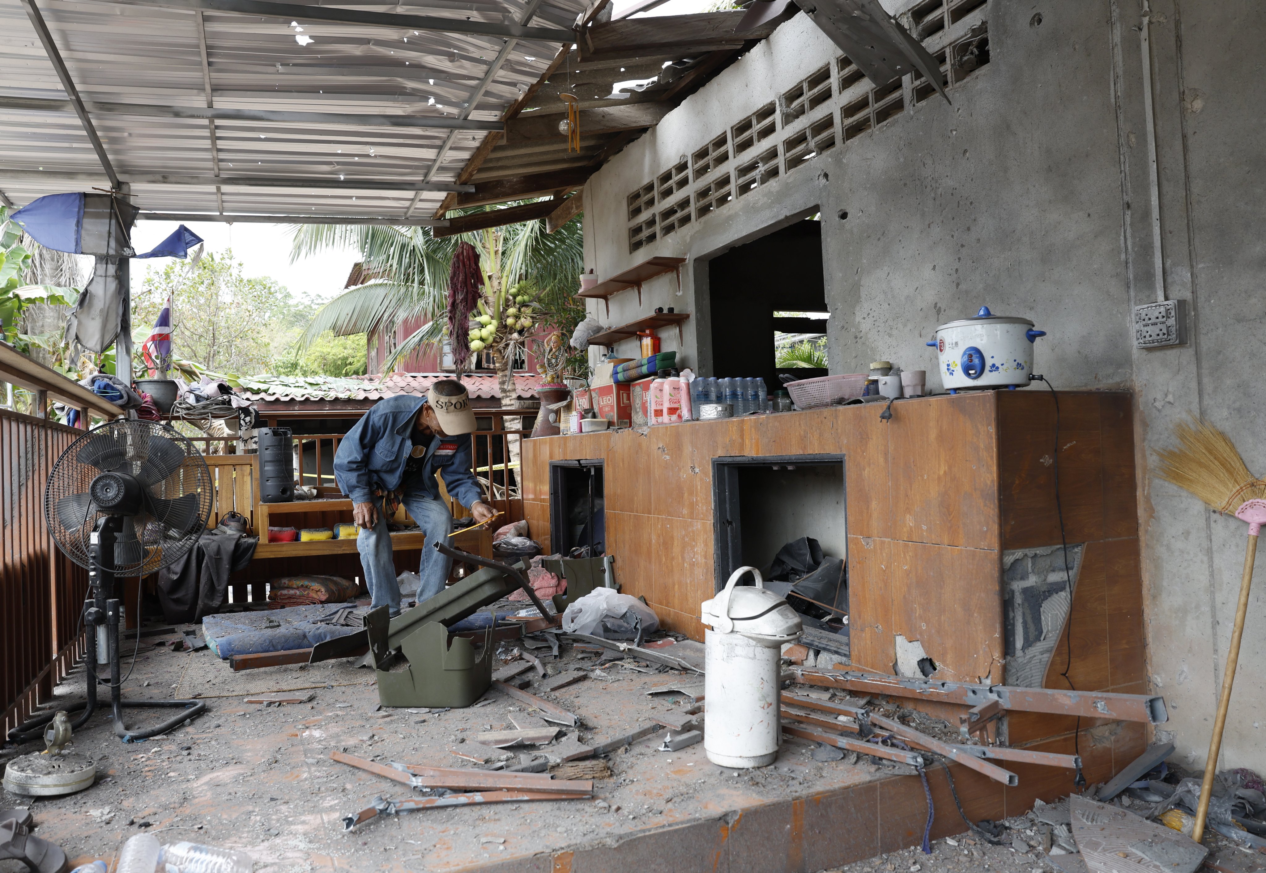 A Thai villager inspects his house damaged during clashes between Thai and Cambodian troops, at a village in Surin province, Thailand, on Tuesday. Photo: EPA