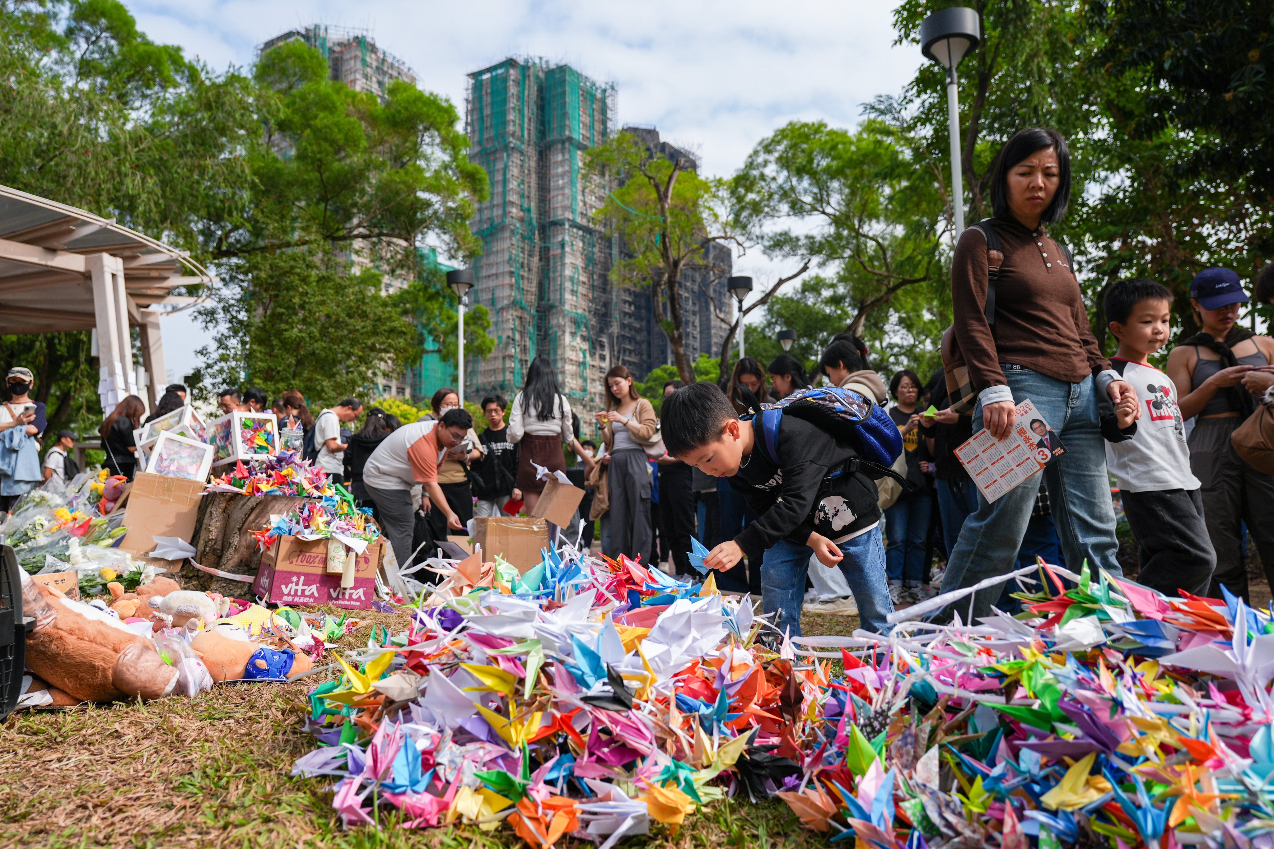 Mourners gather at Kwong Fuk Sitting-out Area to mourn victims of the deadly fire at Wang Fuk Court in Tai Po. Photo: Eugene Lee