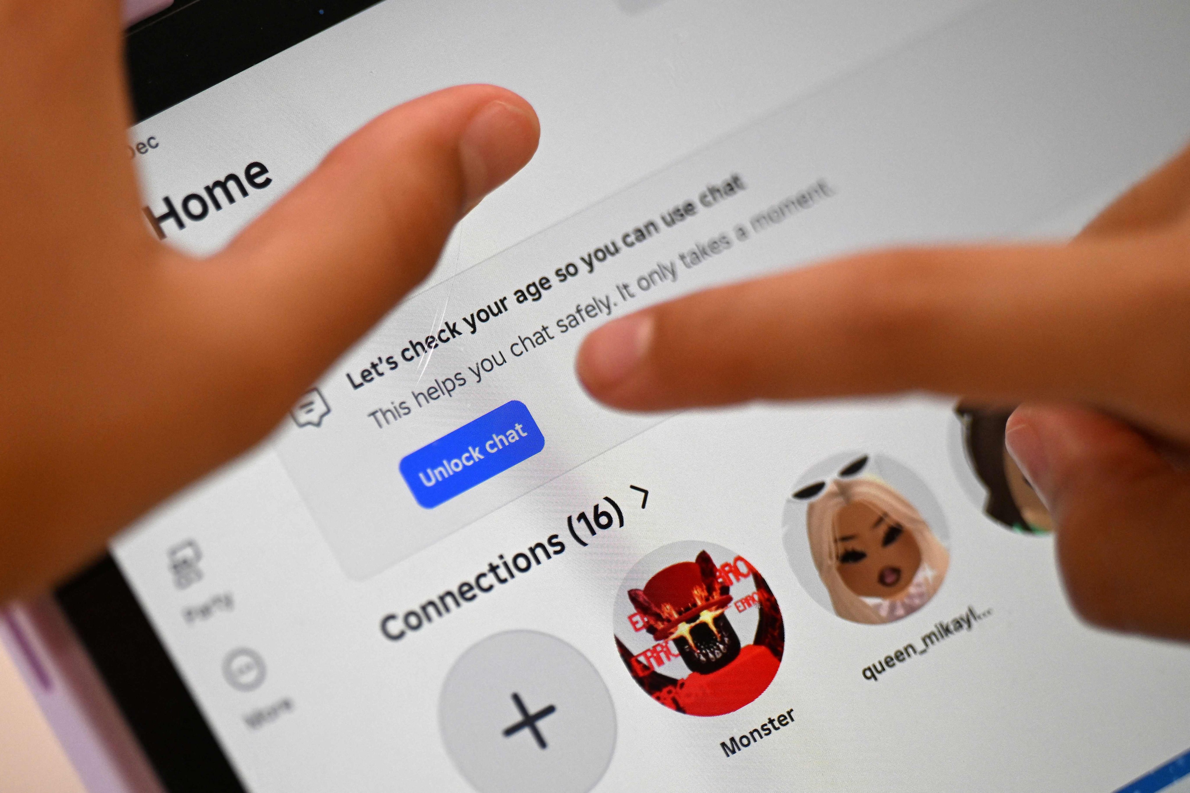 A child tries to unlock a social media site after receiving an age verification message at her home in Sydney on December 10. Photo: AFP