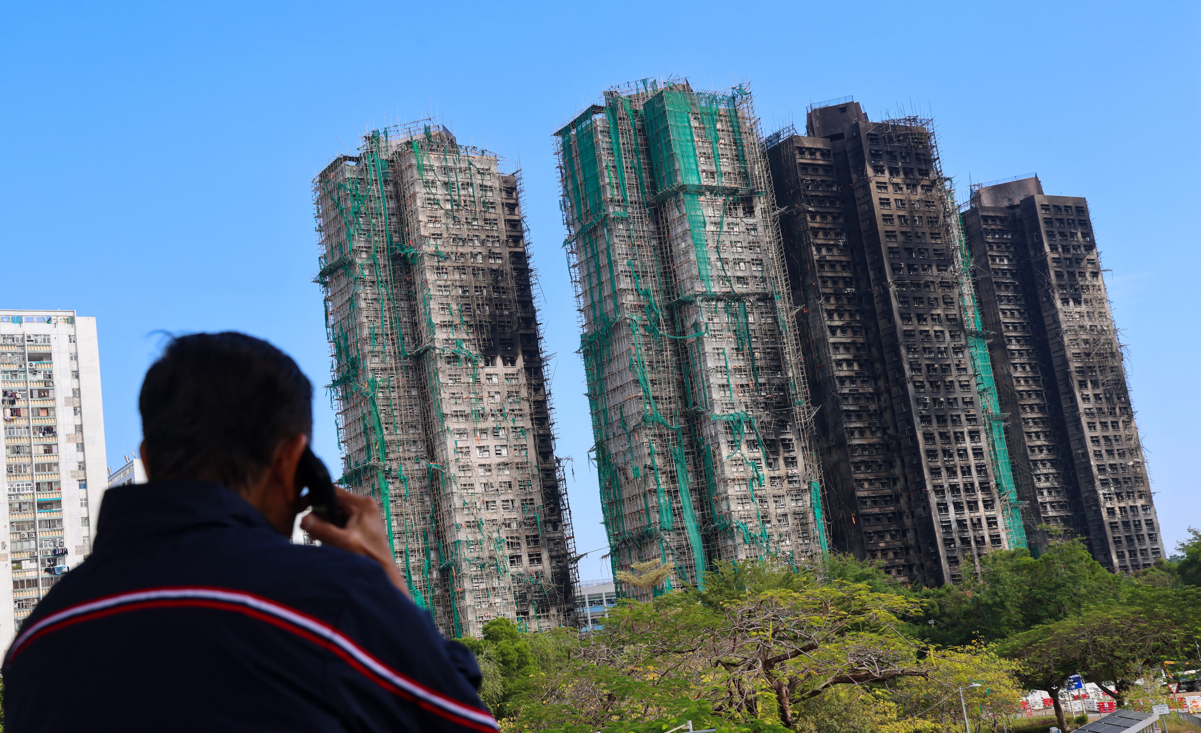 A man stands in front of the aftermath of the deadly fire at Wang Fuk Court in Tai Po, on December 11. Photo: Jelly Tse