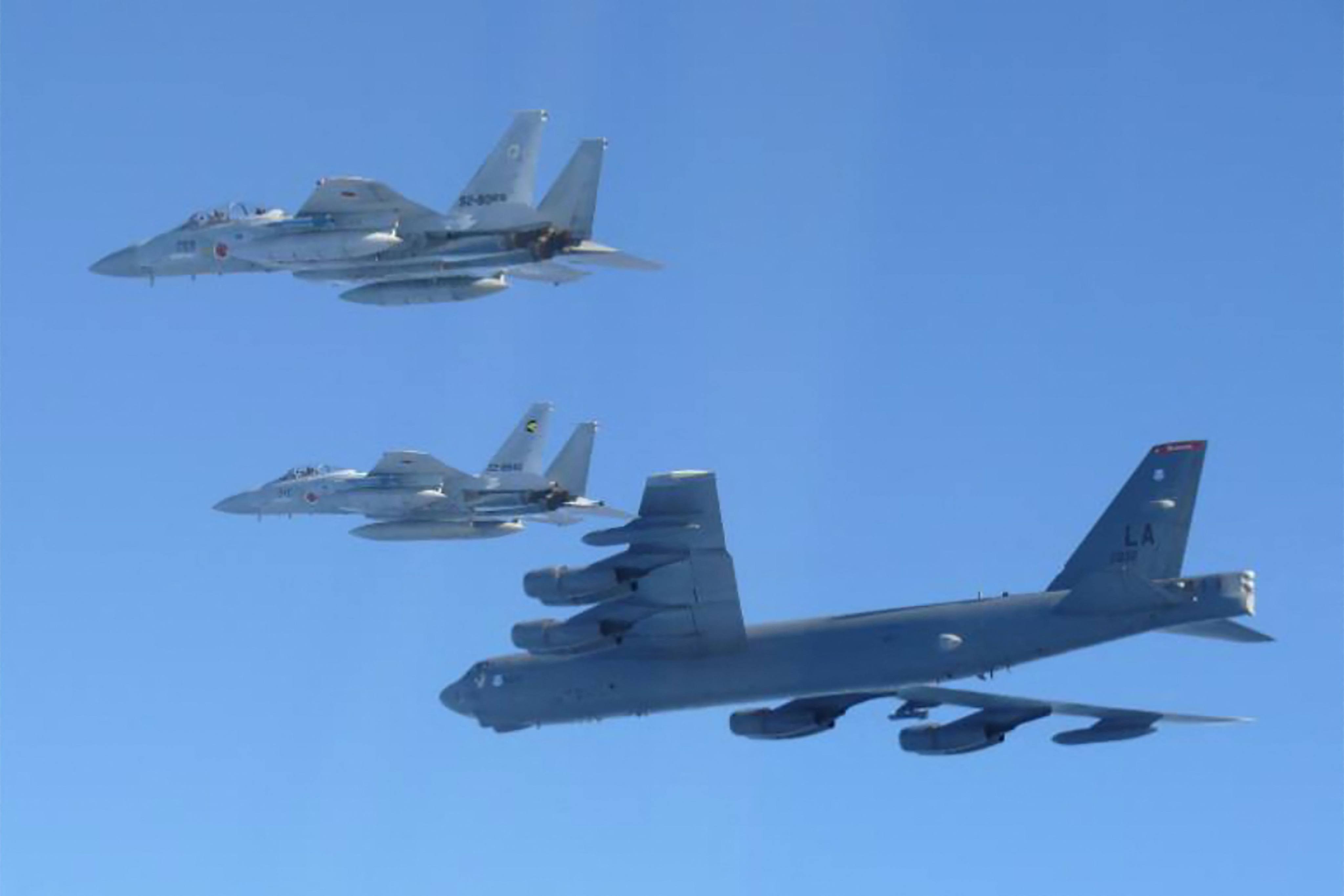 A US B-52 strategic bomber (bottom) and Japanese F-15 fighter jets take part in a joint exercise over the Sea of Japan on Wednesday. Photo: AFP