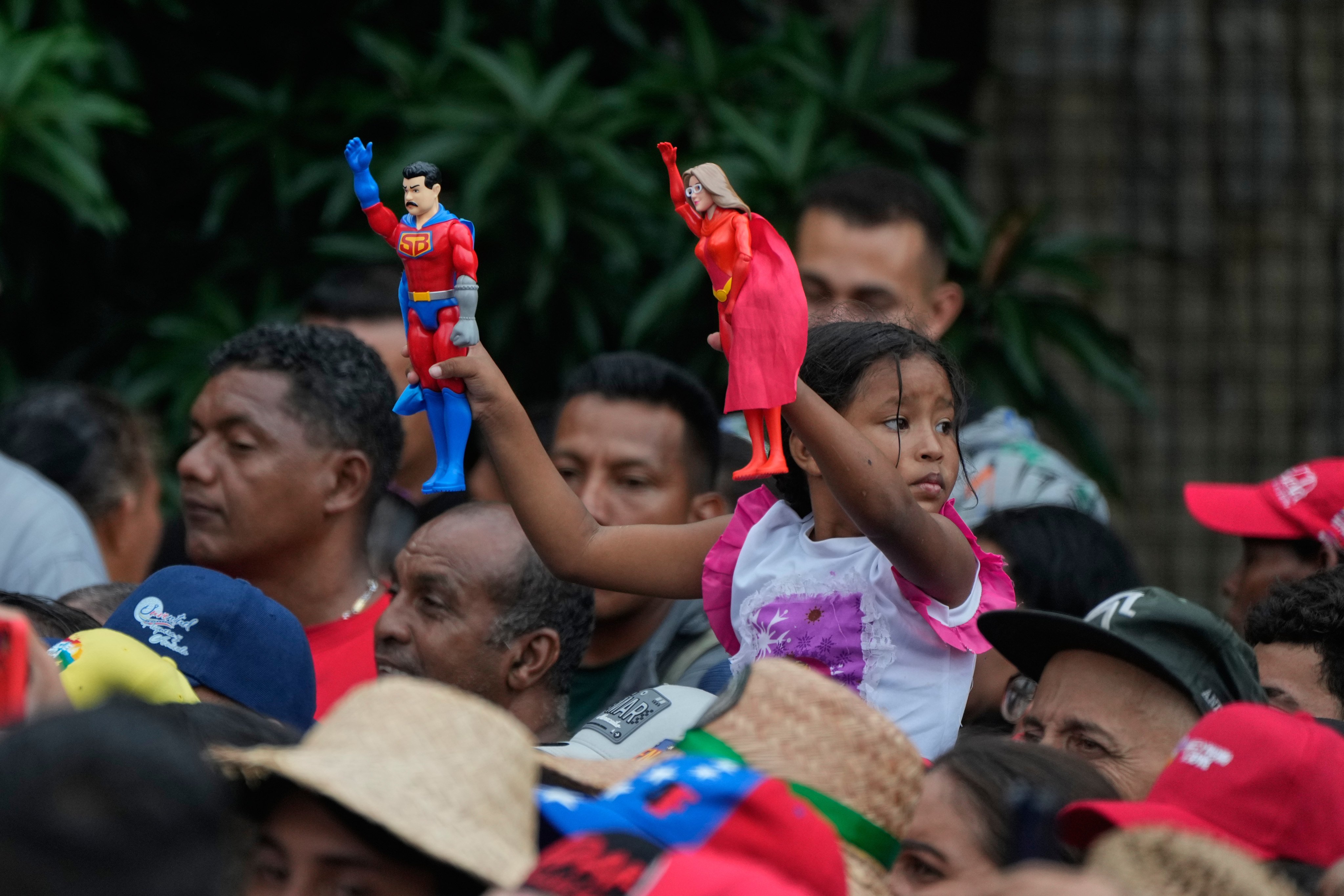A child holds action figures of Venezuelan President Nicolas Maduro and first lady Cilia Flores at a rally in Caracas on Wednesday. Photo: AP