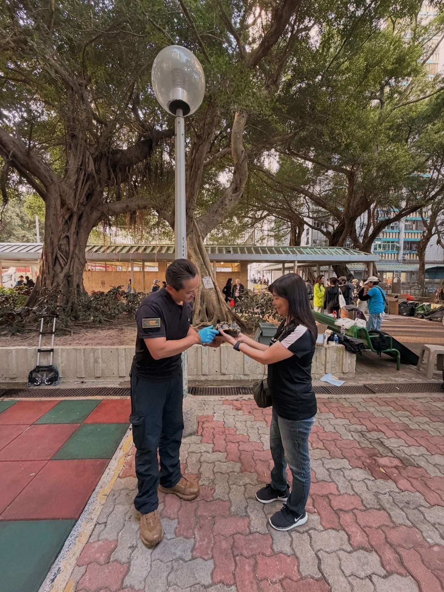 Bon Chan (left) reunites a pet owner with her turtle rescued from the fire at Wang Fuk Court. Photo: Handout