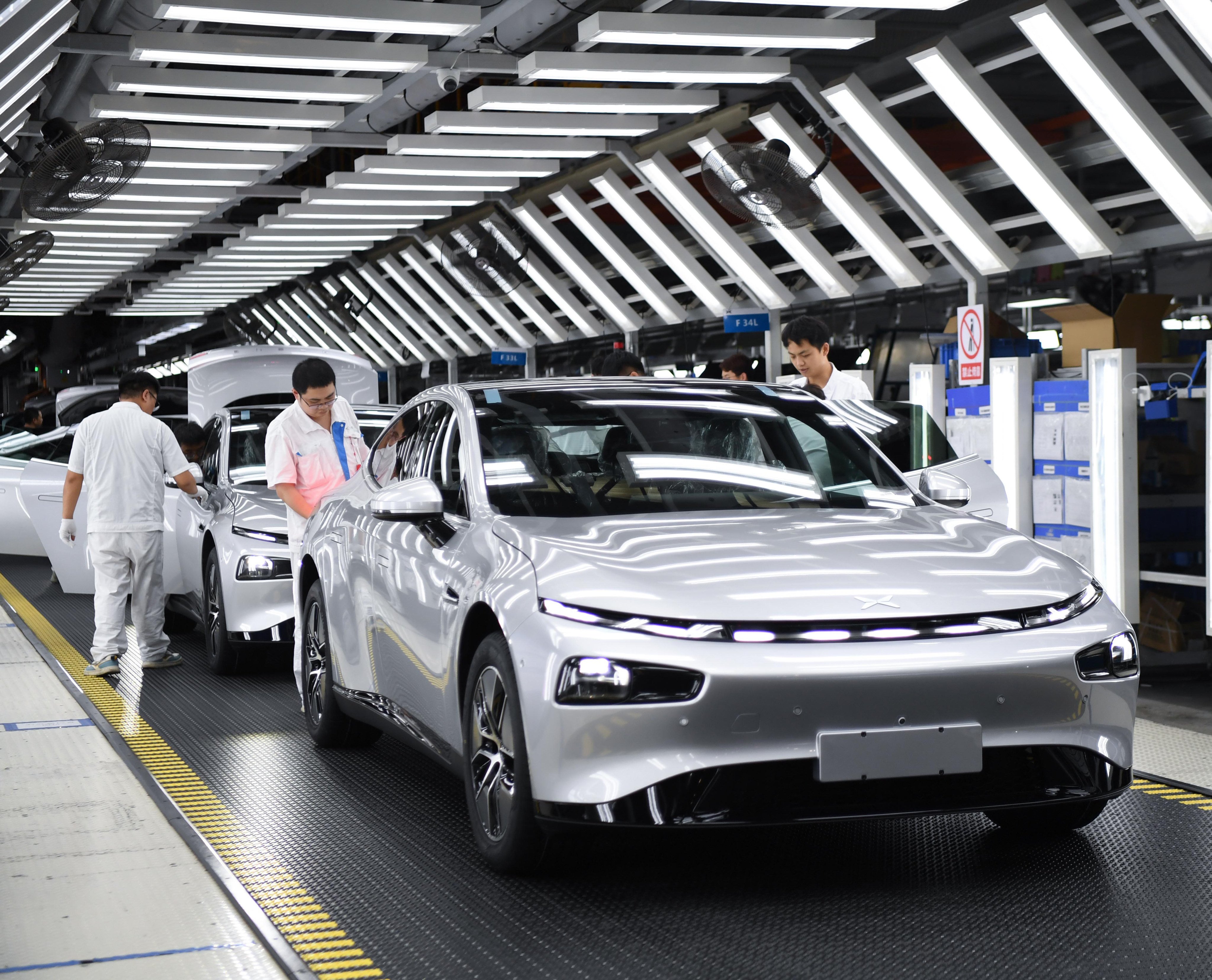 Workers conduct final checks on an Xpeng new energy car at the firm’s plant in Zhaoqing,  Guangdong province, on October 9, 2023. Photo: Xinhua
