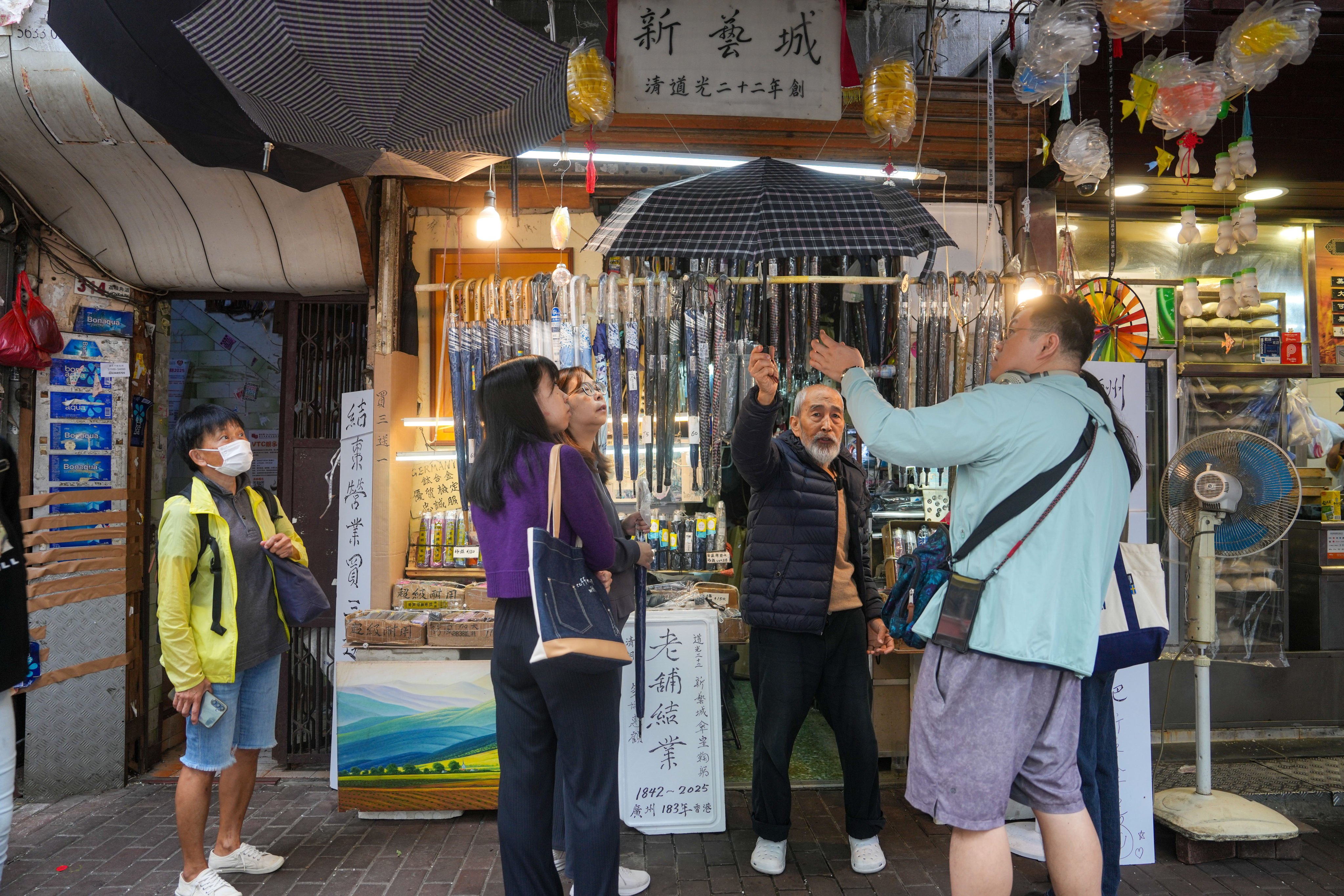 Yau Yiu-wai (black jacket), 73, owner of Sun Nga Shing Umbrella Store in Sham Shui Po, has enjoyed a recent bump in sales but will nonetheless close his 183-year-old business by the end of this month. Photo: Sam Tsang