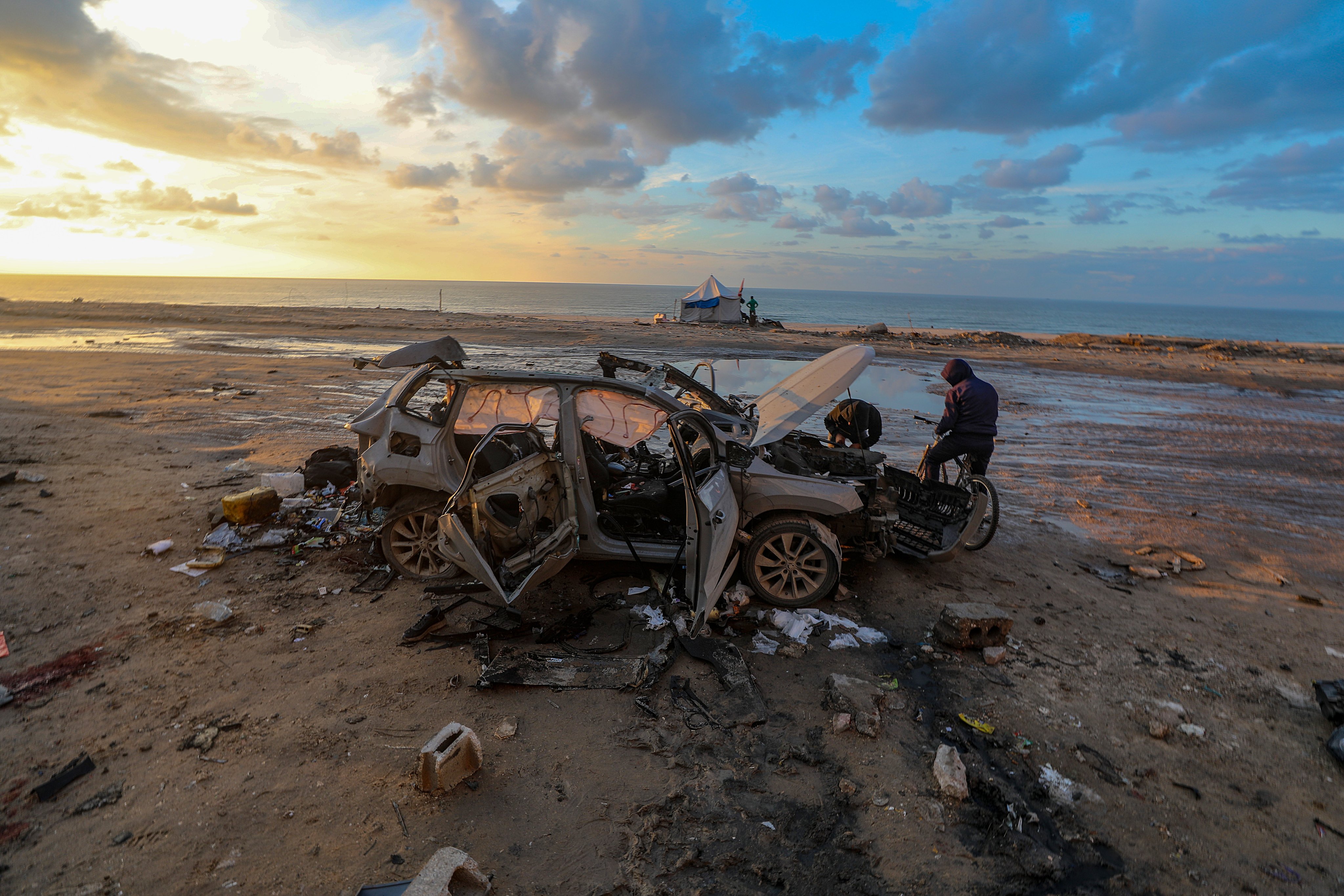 A car destroyed in an Israeli strike is seen on Saturday near the Nablusi junction in the Gaza City area. Photo: EPA