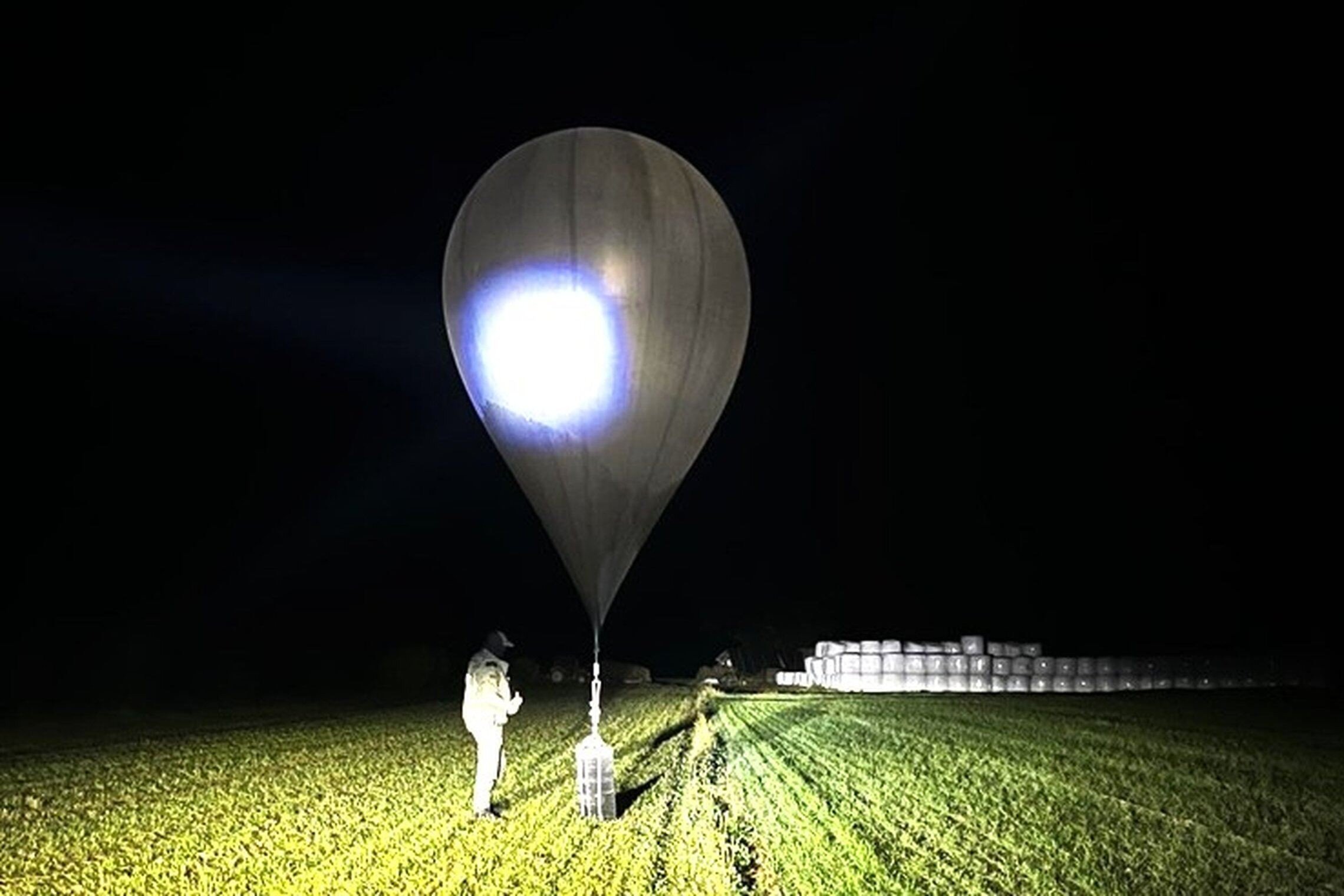 An  undated image shows an officer inspecting a balloon used to smuggle cigarettes into Lithuania. Photo: State Border Guard Service via AP