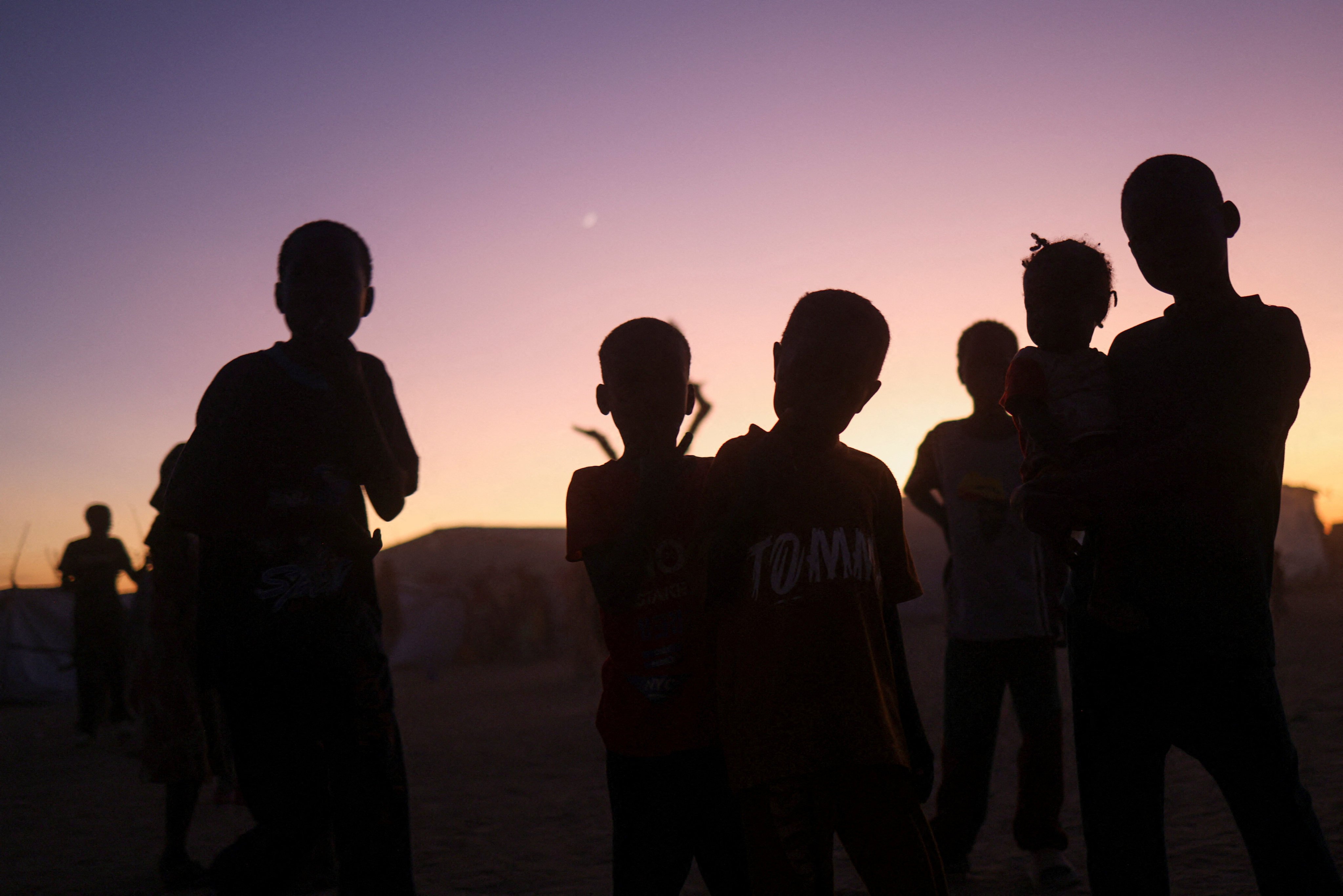 Sudanese refugee children stand at sunset in a transit camp amid the conflict between the paramilitary Rapid Support Forces (RSF) and the Sudanese Army, in November. Photo: Reuters