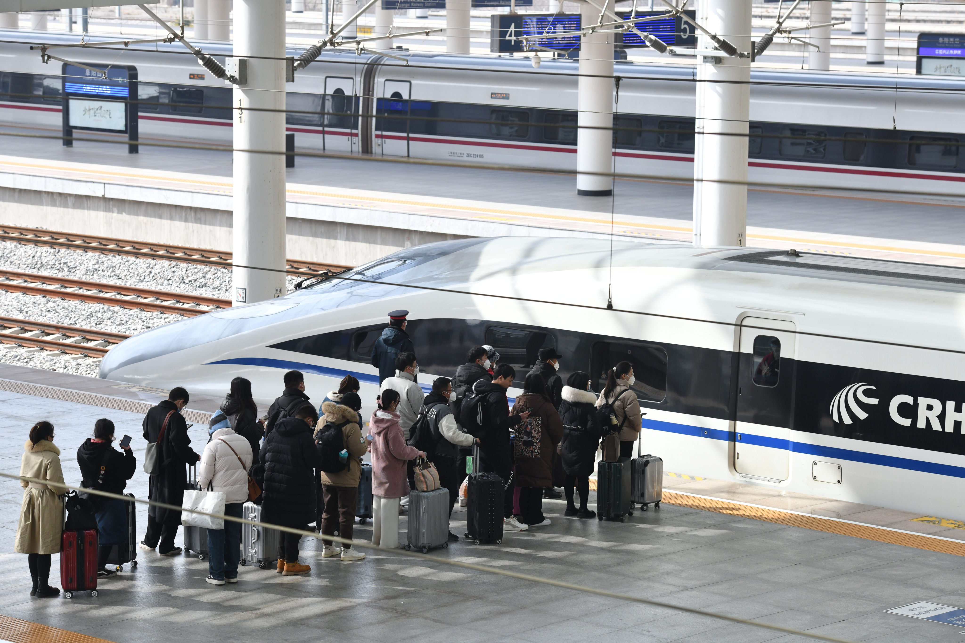 Passengers line up to board a high-speed train at a station in central China’s Anhui province. Photo: Xinhua