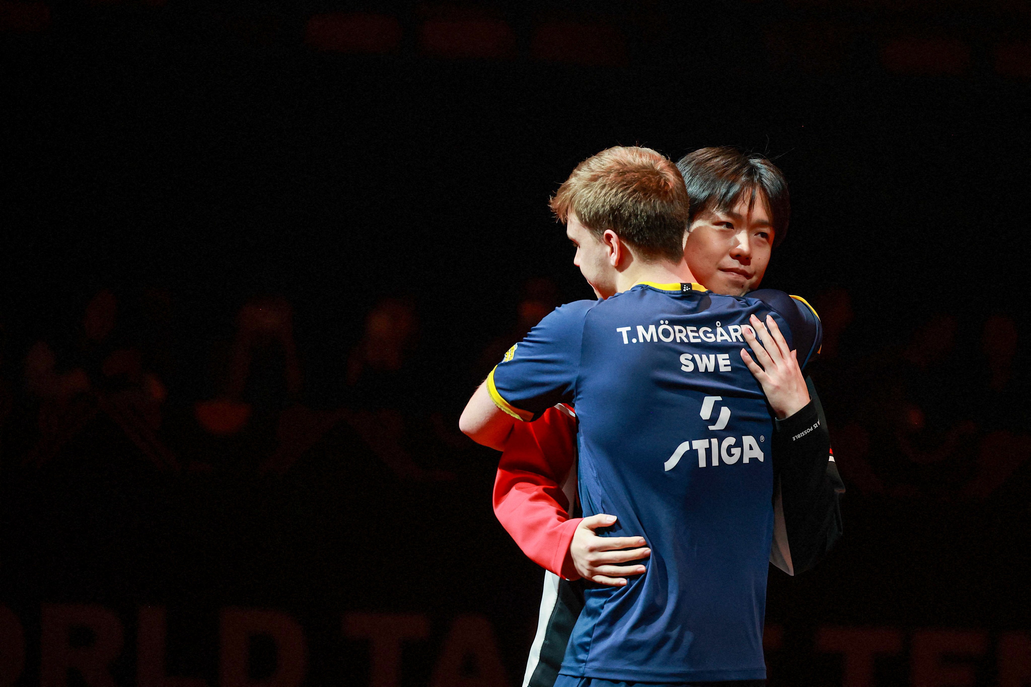 Wang Chuqin and Truls Moregard hug after it was announced Wang had pulled out of their semi-final. Photo: AFP