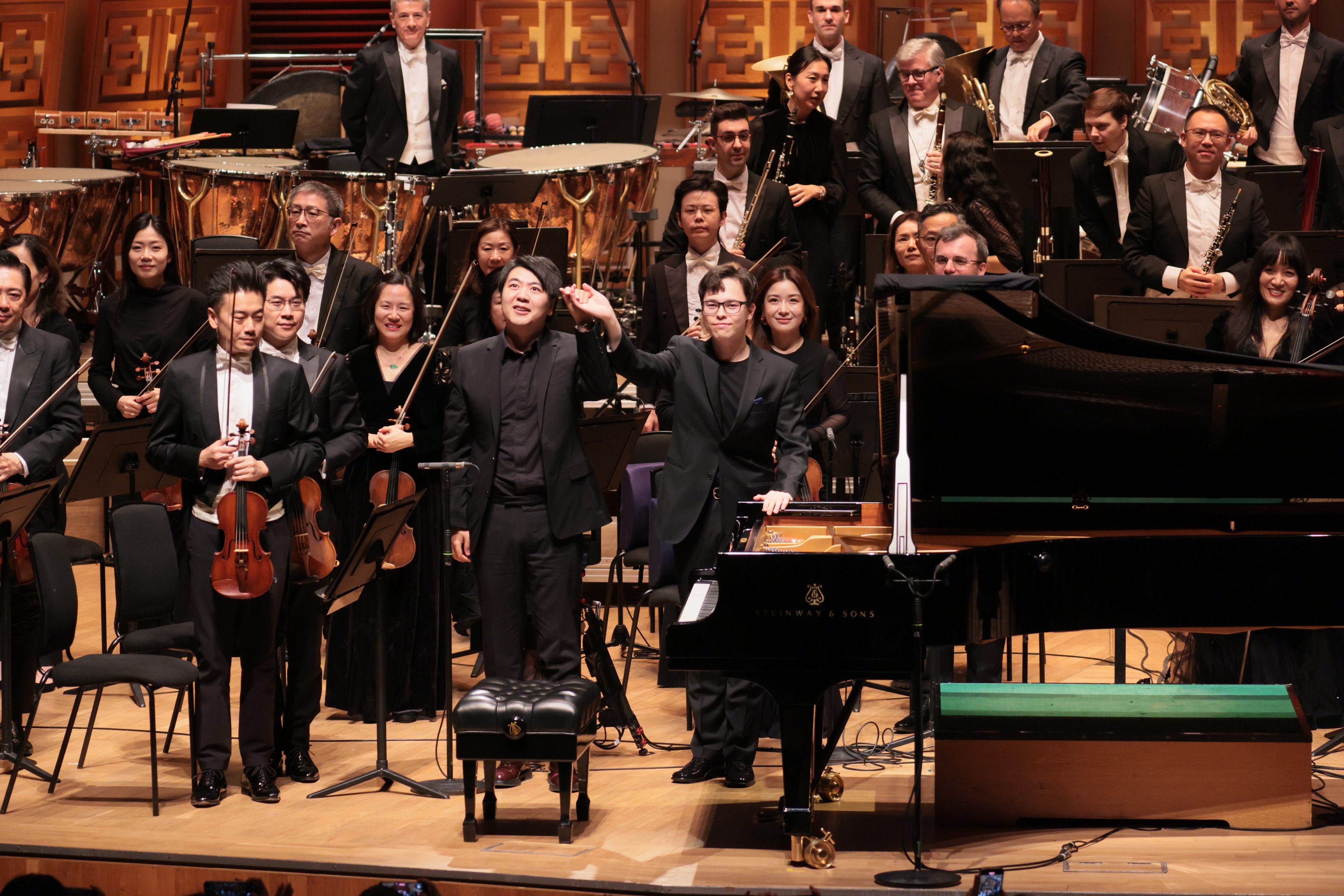 Finnish conductor Tarmo Peltokoski (centre right) raises his hand with Chinese pianist Lang Lang on stage with the Hong Kong Philharmonic Orchestra at the Hong Kong Cultural Centre on December 11, 2025. Photo: HK Phil