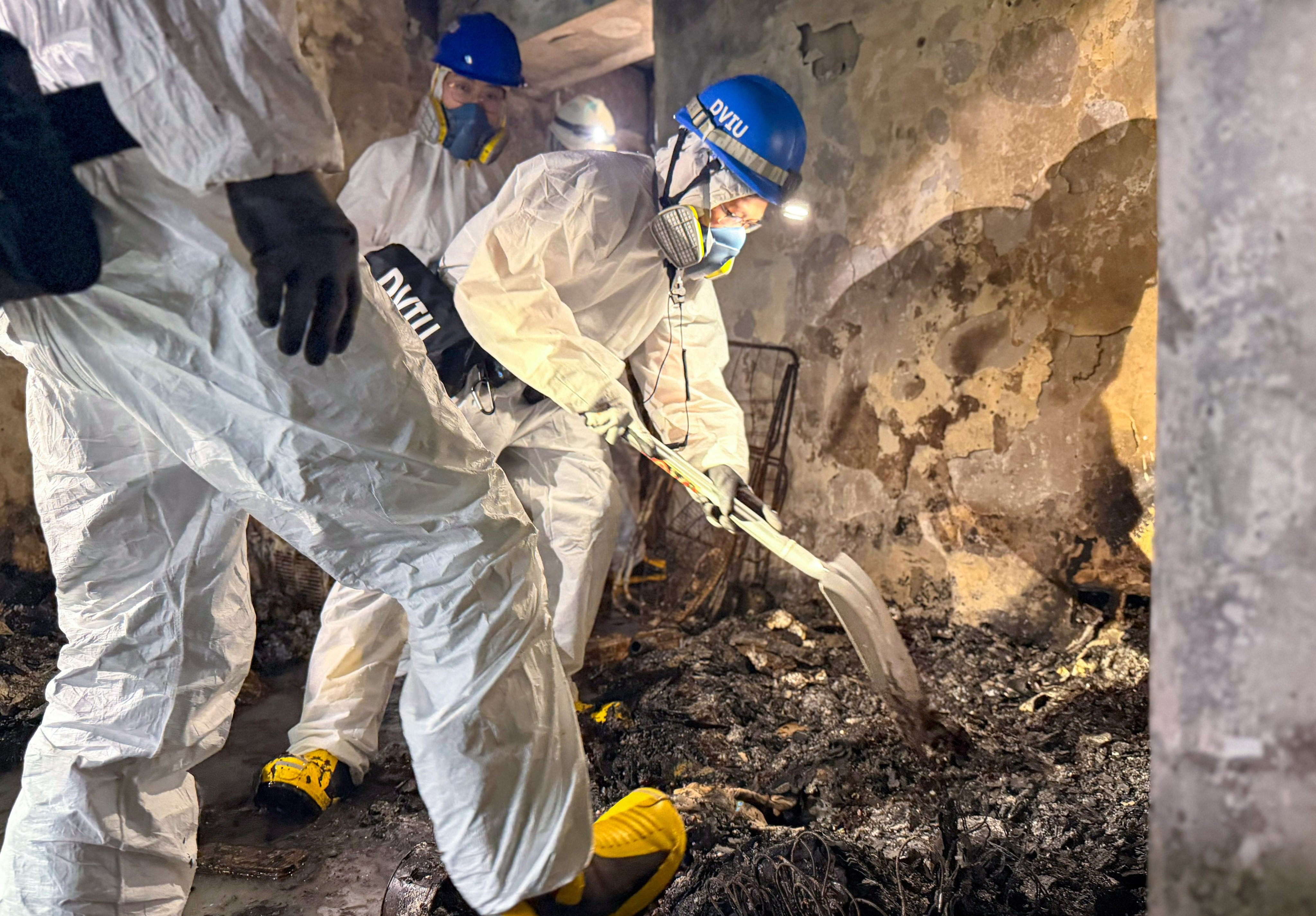 Officers of the Disaster Victim Identification Unit search the remains of a building destroyed in last month’s catastrophic fire in Tai Po. Photo: Handout