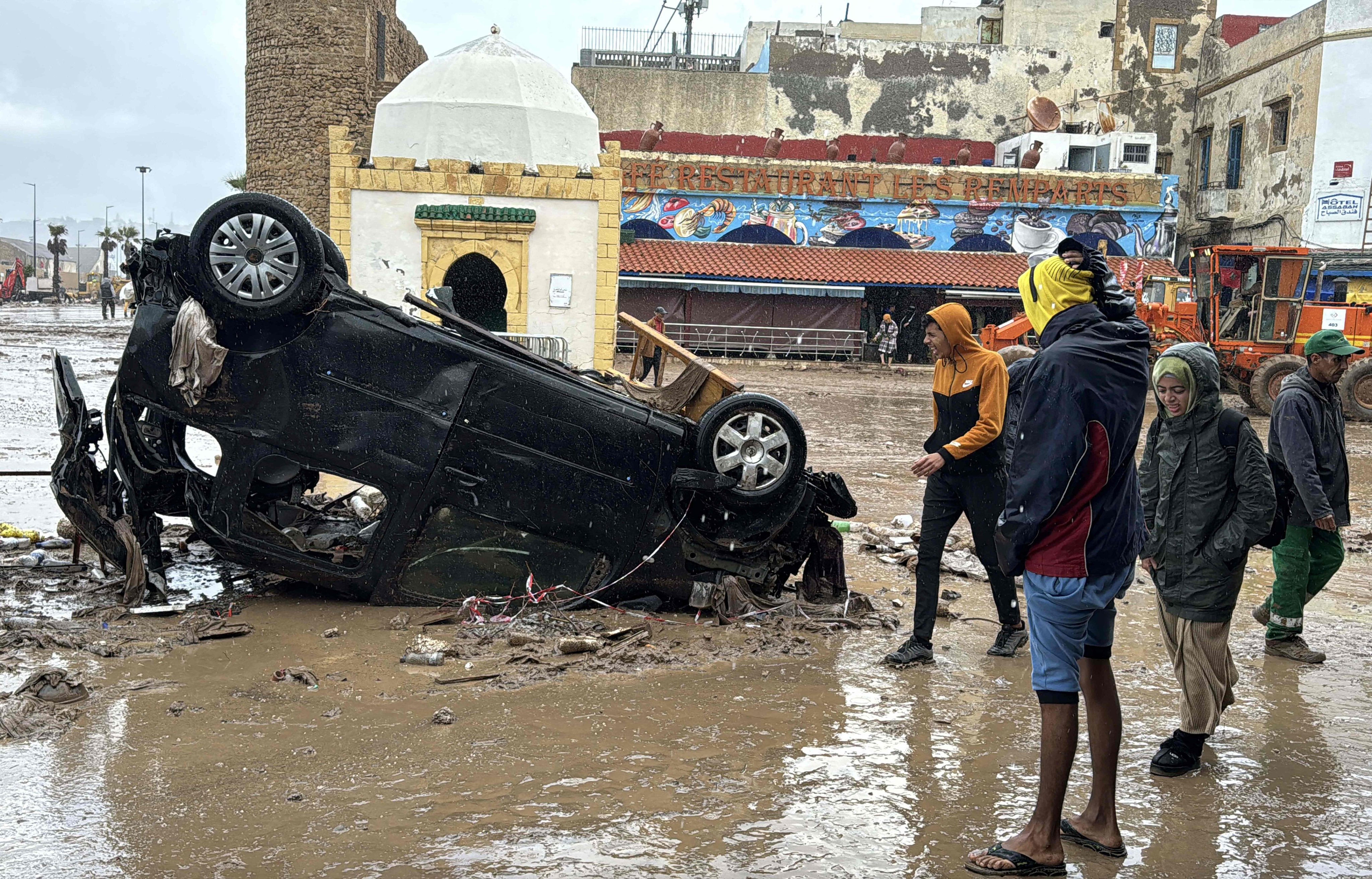 Moroccans looks at a destroyed car following fatal flash floods in the coastal town of Safi. Photo: AFP