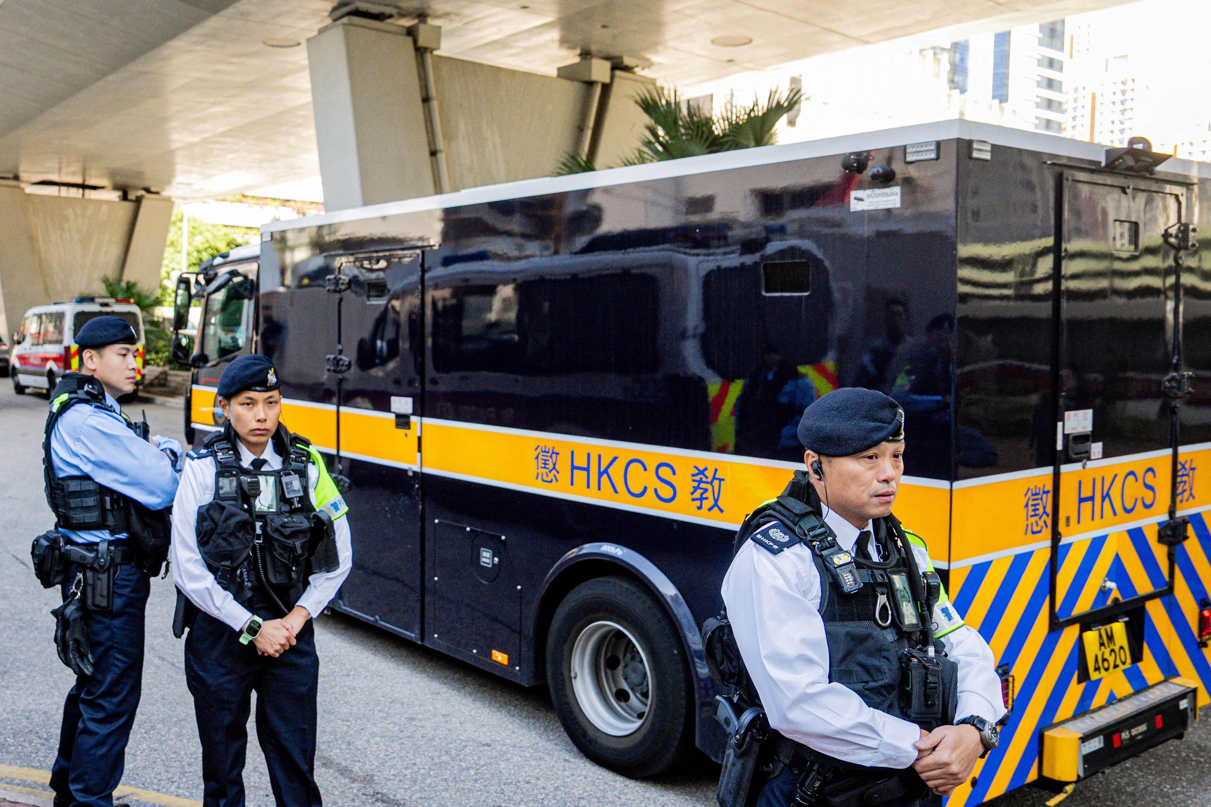 Police officers keep watch as a van transporting media tycoon Jimmy Lai leaves the West Kowloon court on Monday in Hong Kong. Photo: AFP