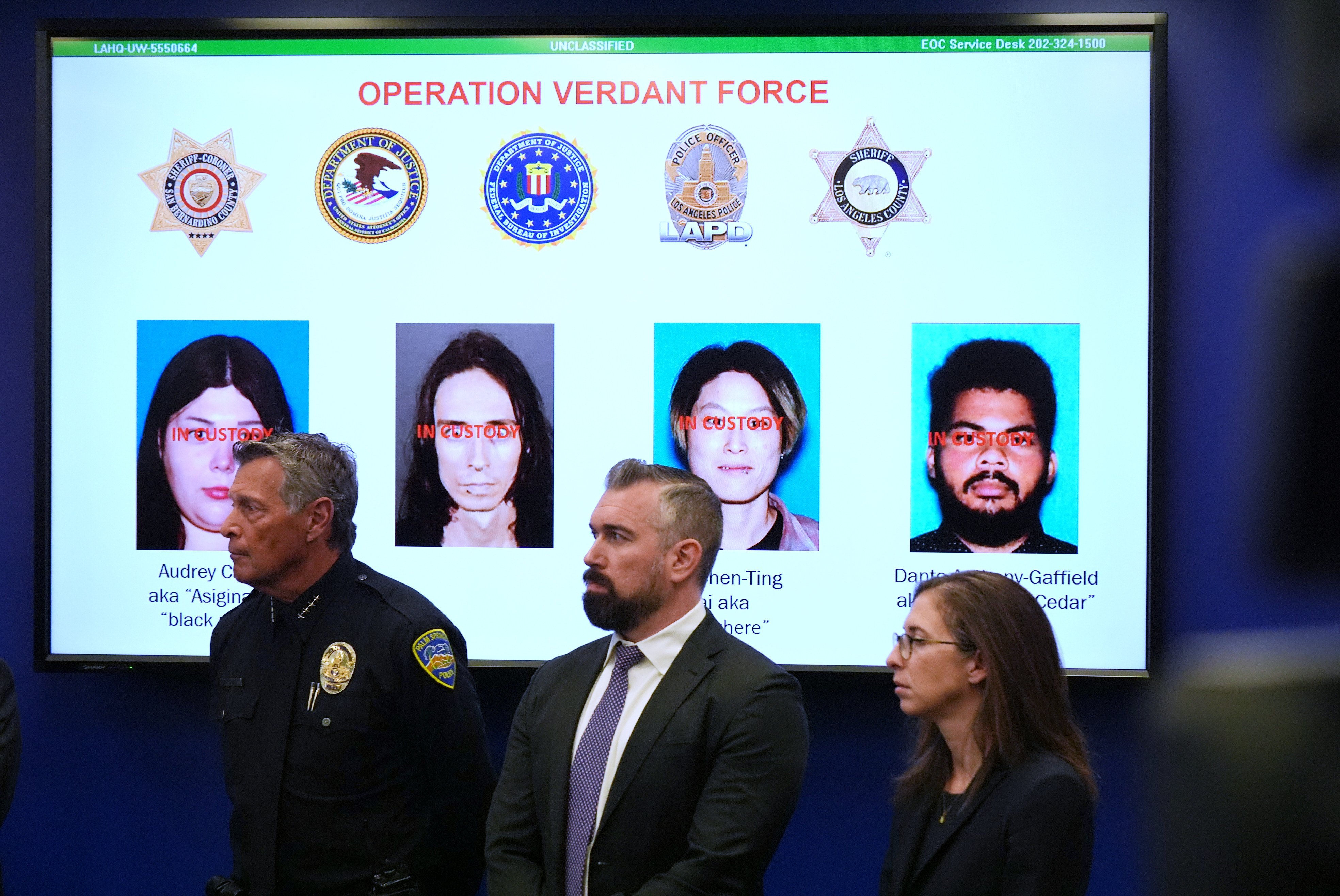 Photos of the suspects are shown on a screen during a press conference in Los Angeles. Photo: AP
