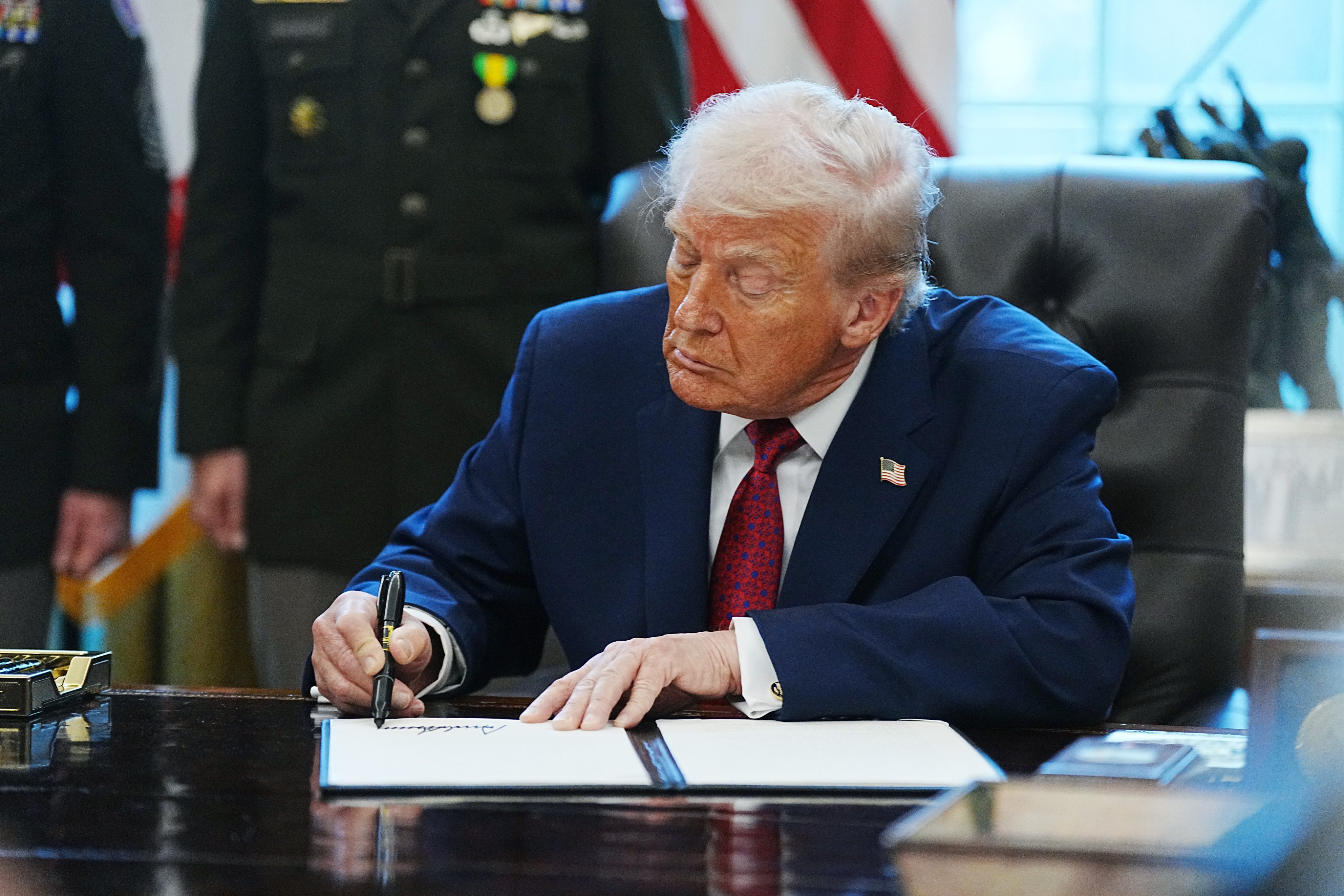 US President Donald Trump signs an executive order designating illicit fentanyl as a weapon of mass destruction in the Oval Office of the White House in Washington on Monday. Photo: EPA