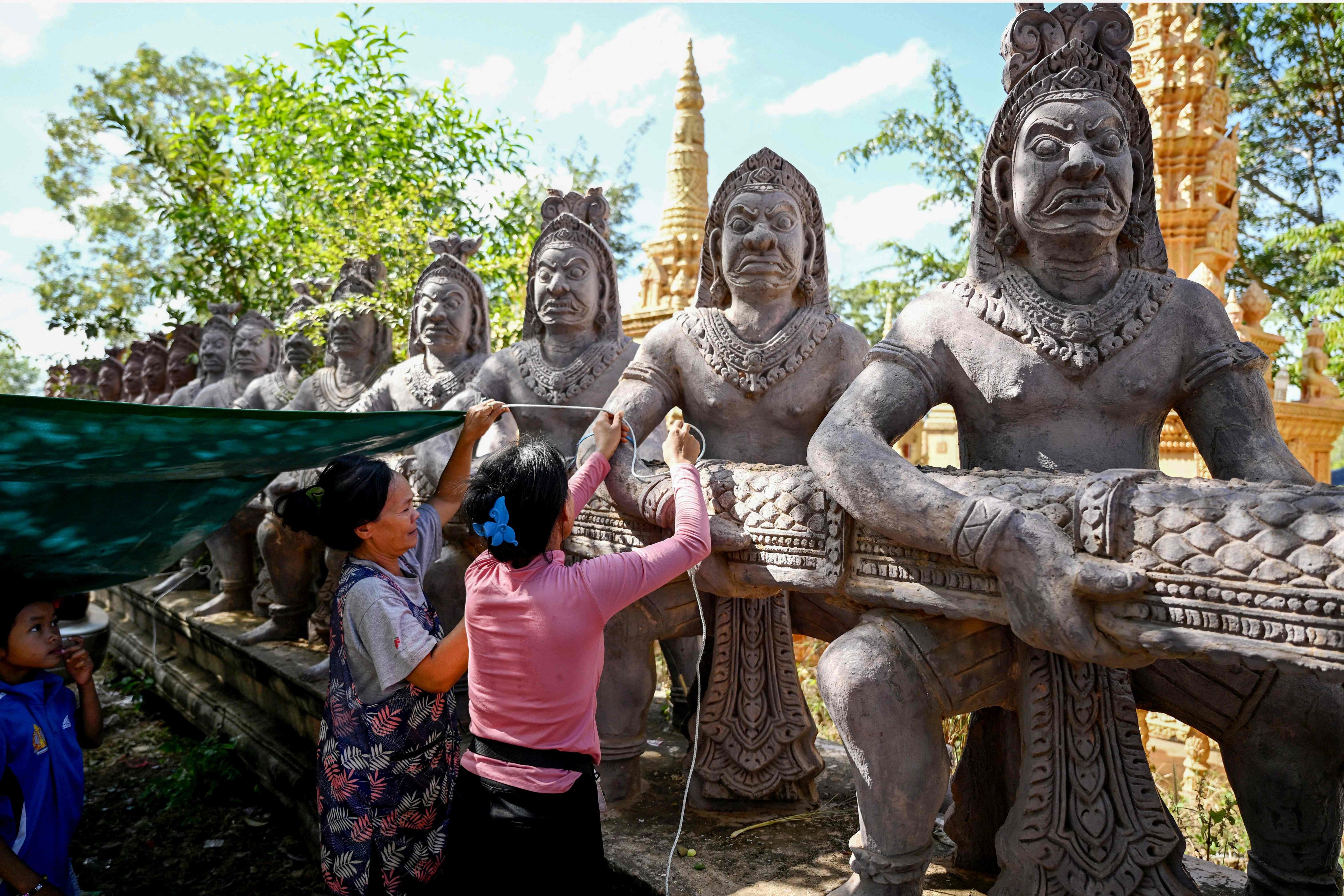 Displaced residents prepare a shelter at a temporary camp set up outside a pagoda in Cambodia’s Siem Reap province on December 12. Photo: AFP