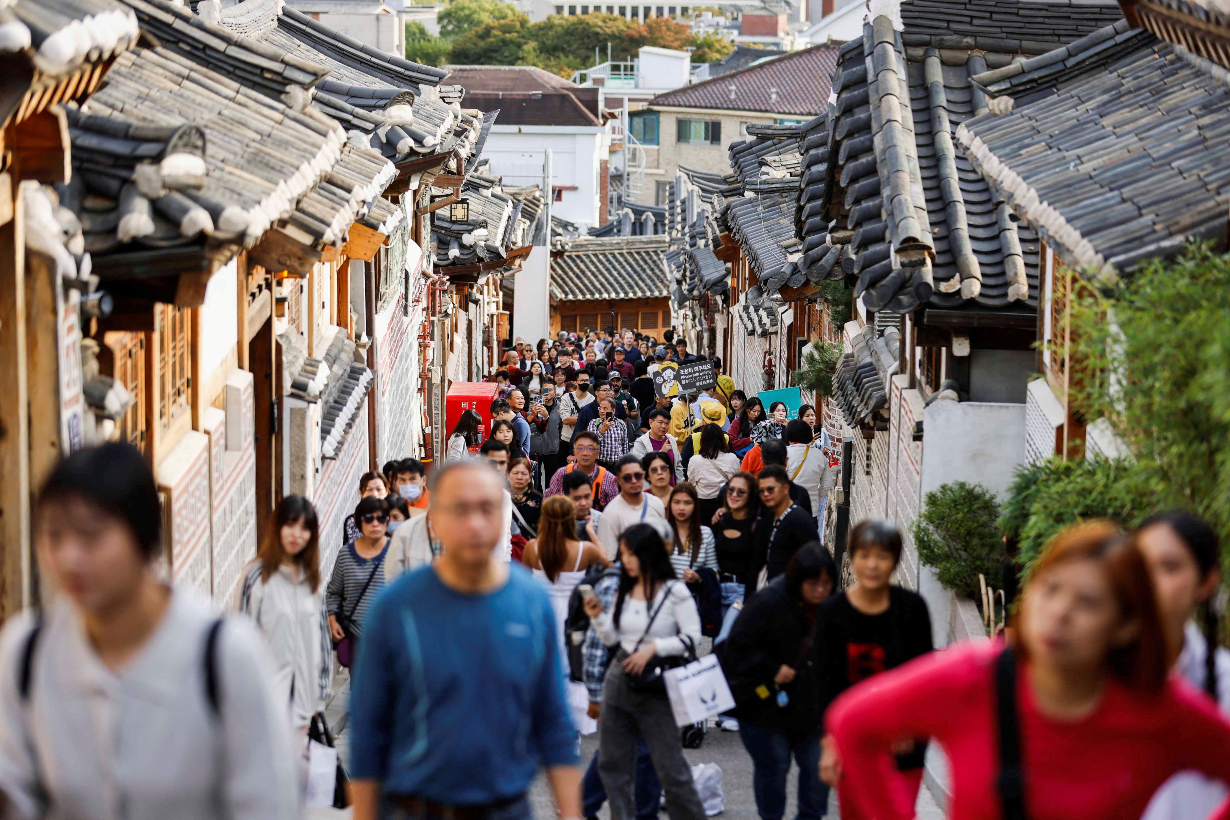 A large crowd of tourists walks through a street in Seoul. South Korea is expected to receive an uptick in Chinese tourism over the coming months. Photo: Reuters