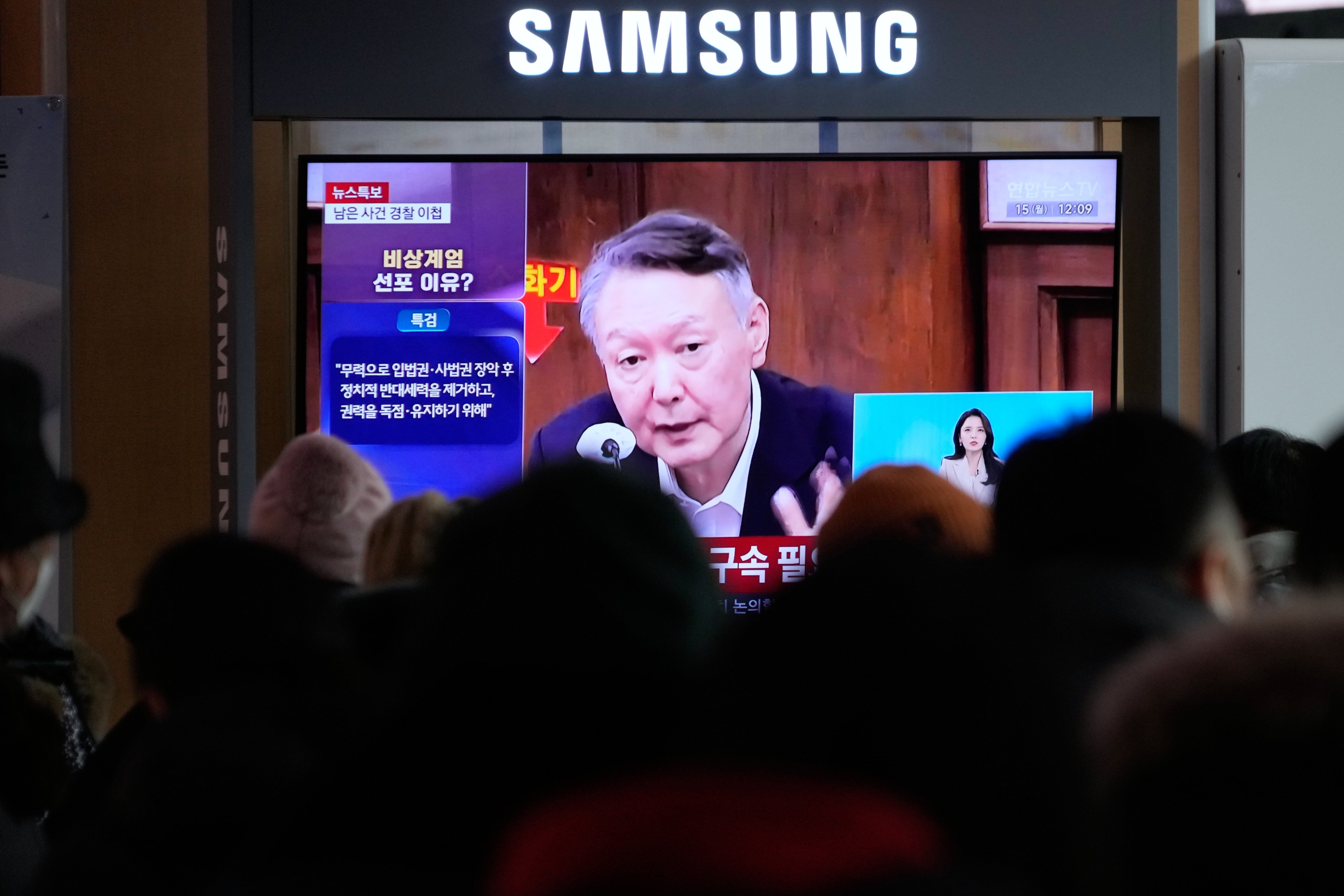 A television screen shows a file image of Yoon Suk-yeol in court at a railway station in Seoul on Monday. Photo: AP