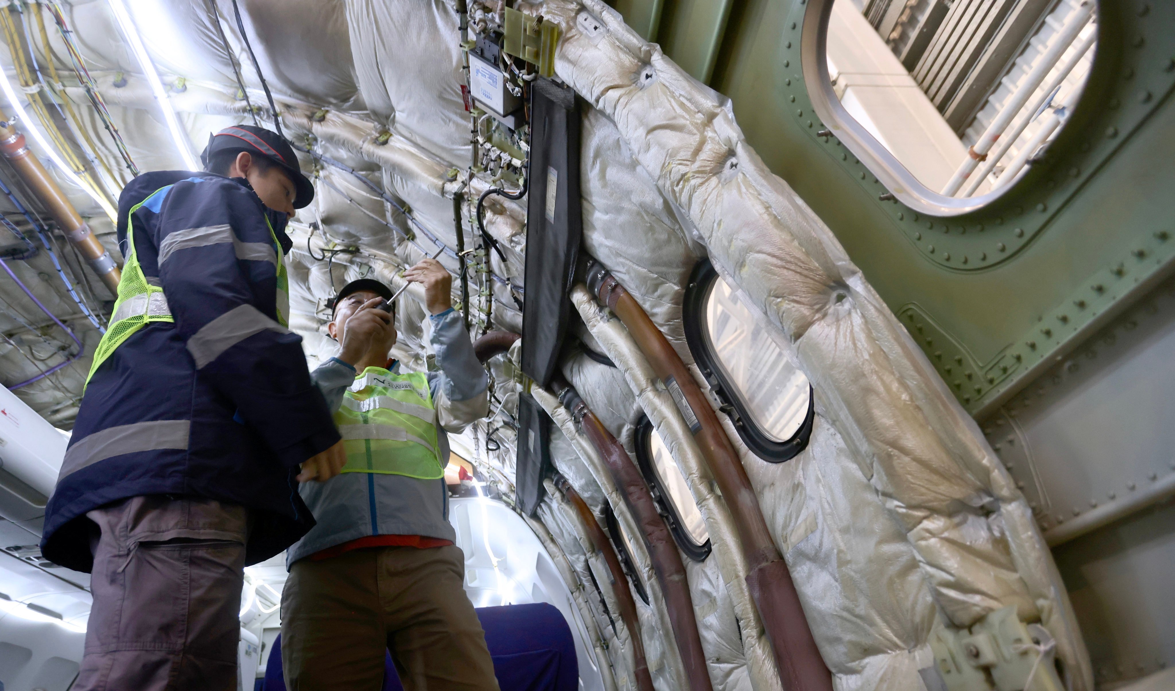Instructor Martin Law (right), who was trained at Elior’s base in France, works with a trainee on an aircraft electrical supply system. Photo: Jonathan Wong