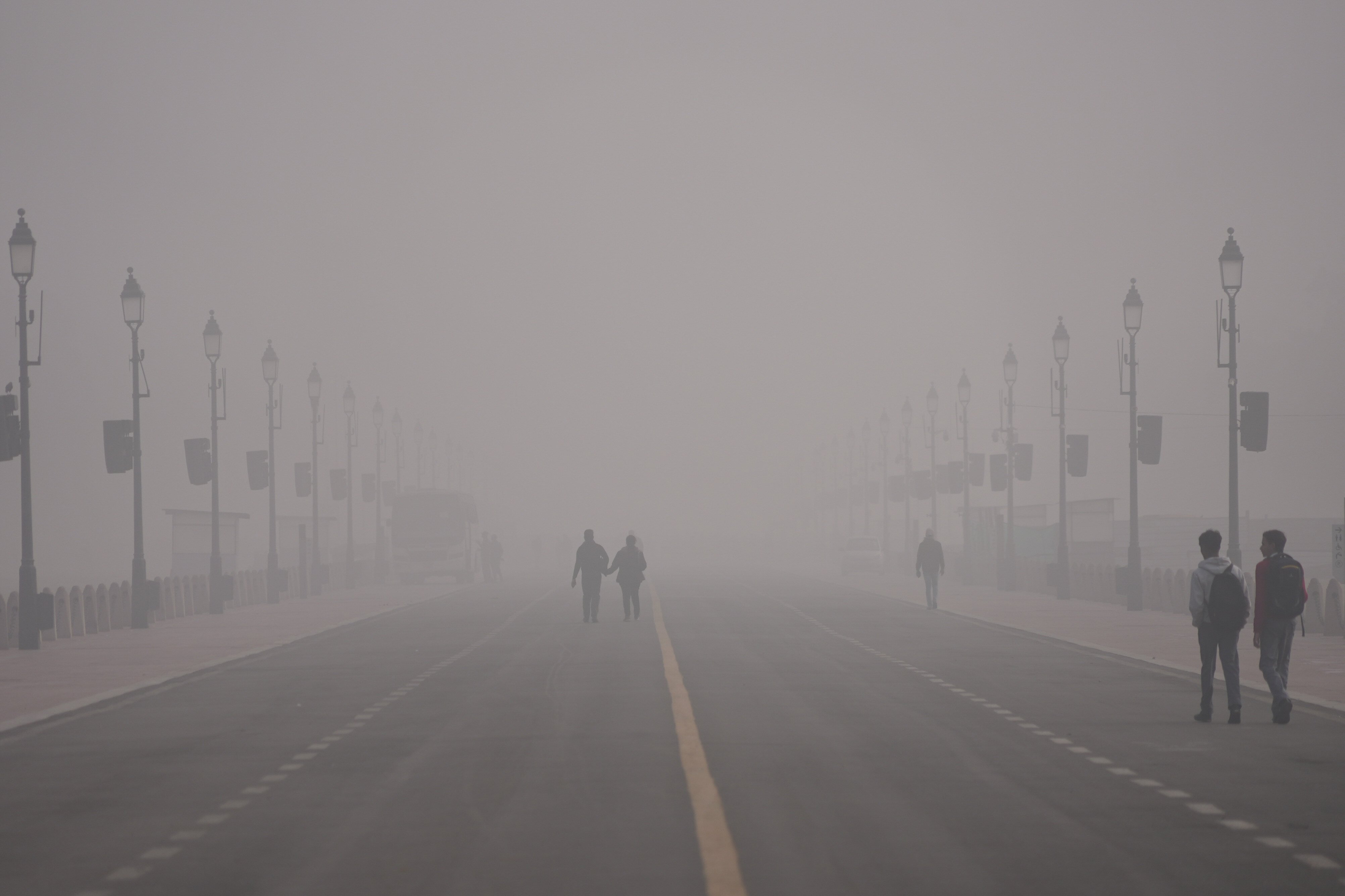 People walk through smog in New Delhi, India, on Monday. Photo: AP