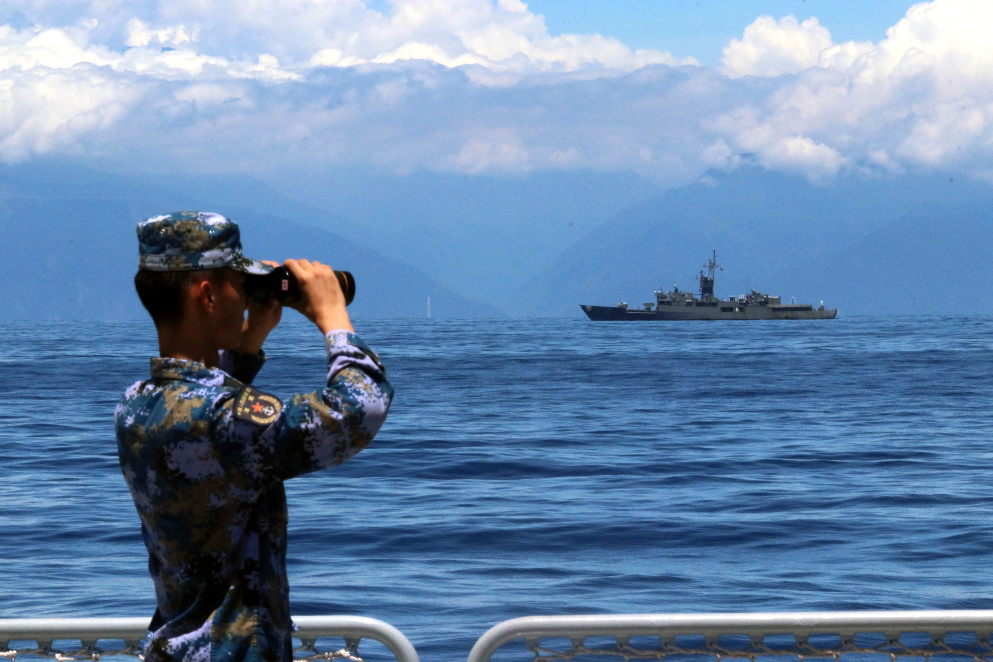 A member of the People’s Liberation Army scans the sea during military exercises, with Taiwan’s frigate Lan Yang in the distance, on August 5, 2022. Photo: Xinhua via AP