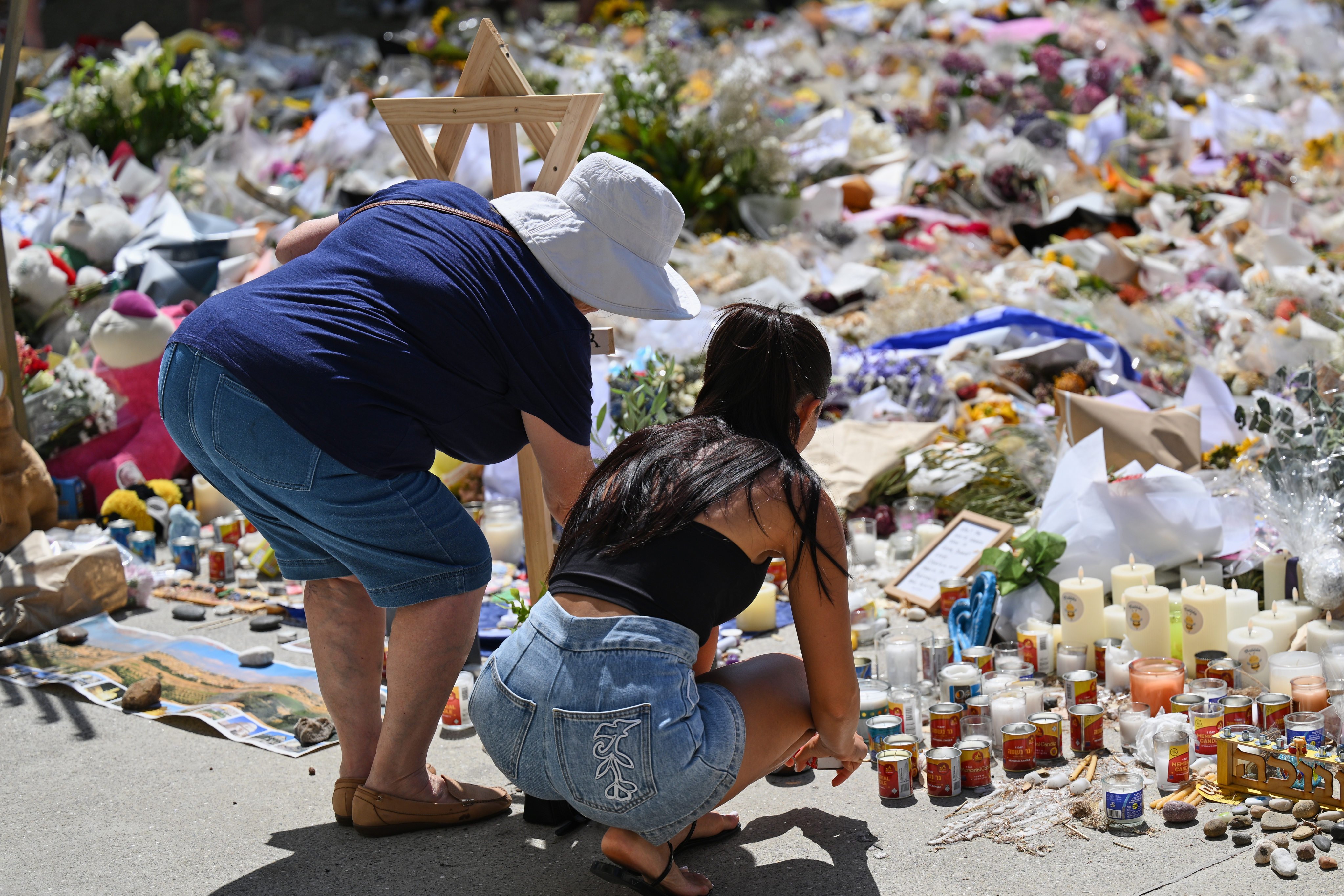 People add to a floral tribute outside Bondi Pavilion at Bondi Beach in Sydney on Thursday. Photo: AP