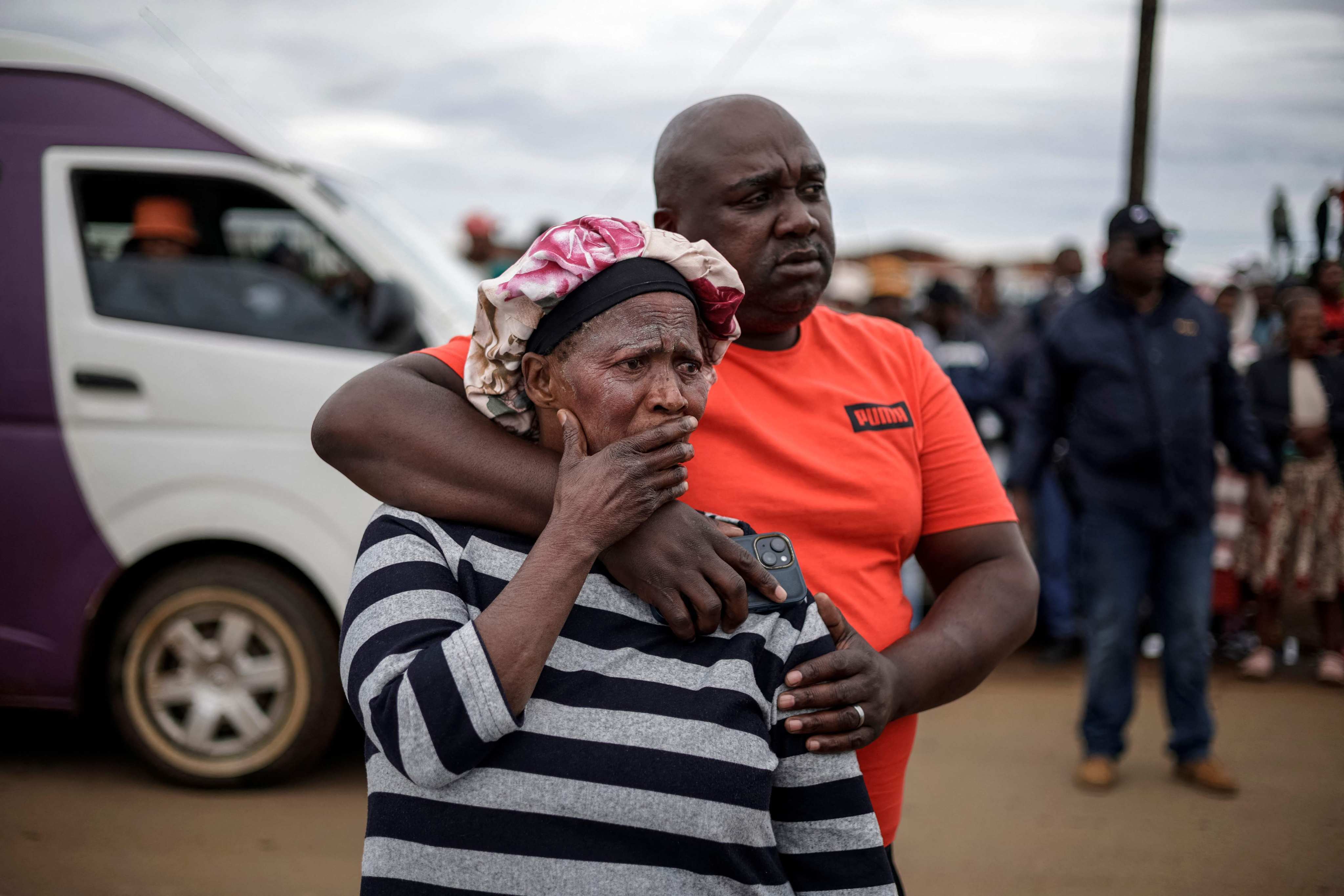 Family members of a victim react at the scene of an attack at a tavern in Bekkersdal, Johannesburg, on Sunday. Photo: AFP