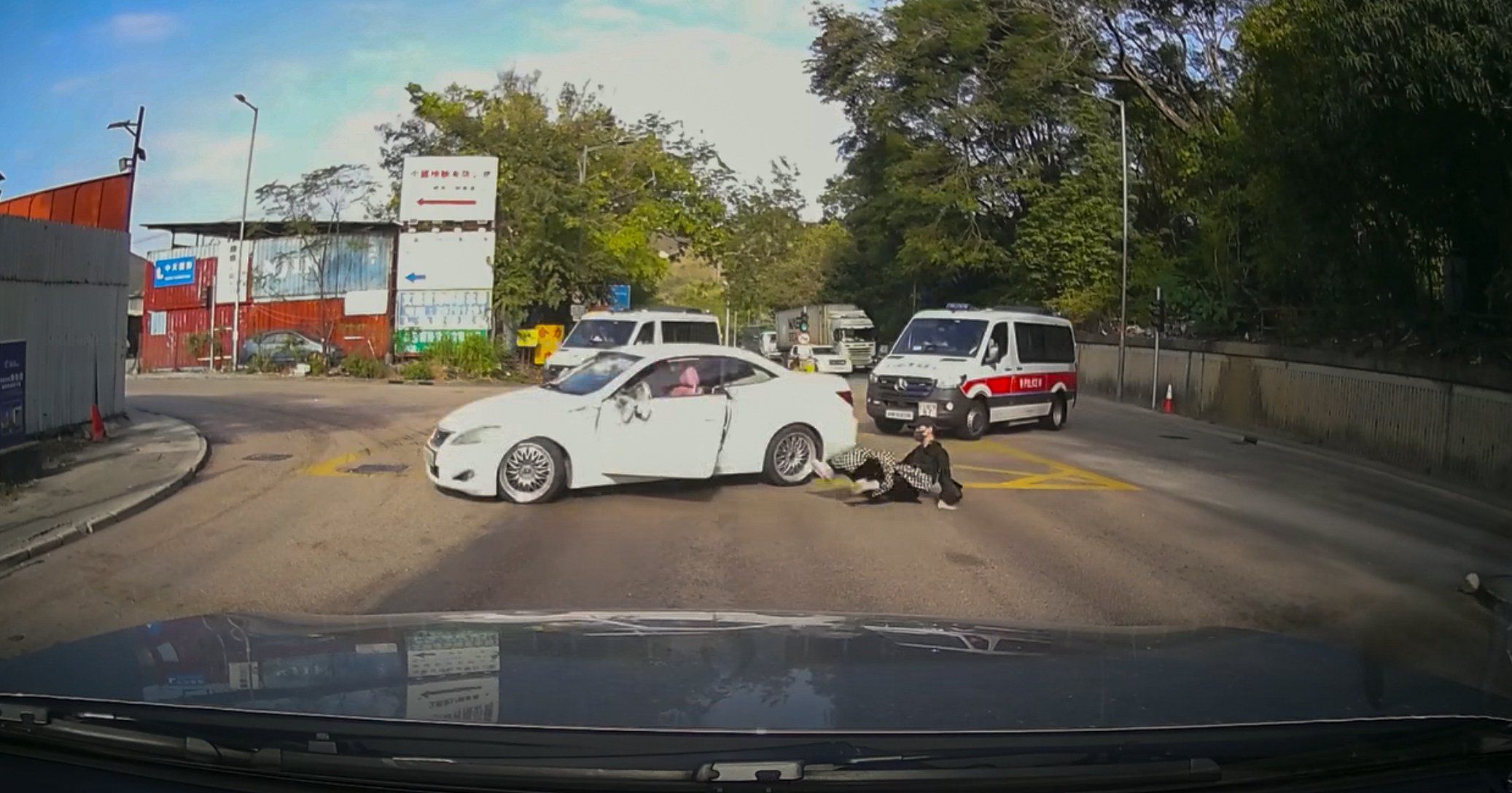 A passenger falls out of the car as police vans chase the suspects. Photo: Facebook/Lau Kai Chung